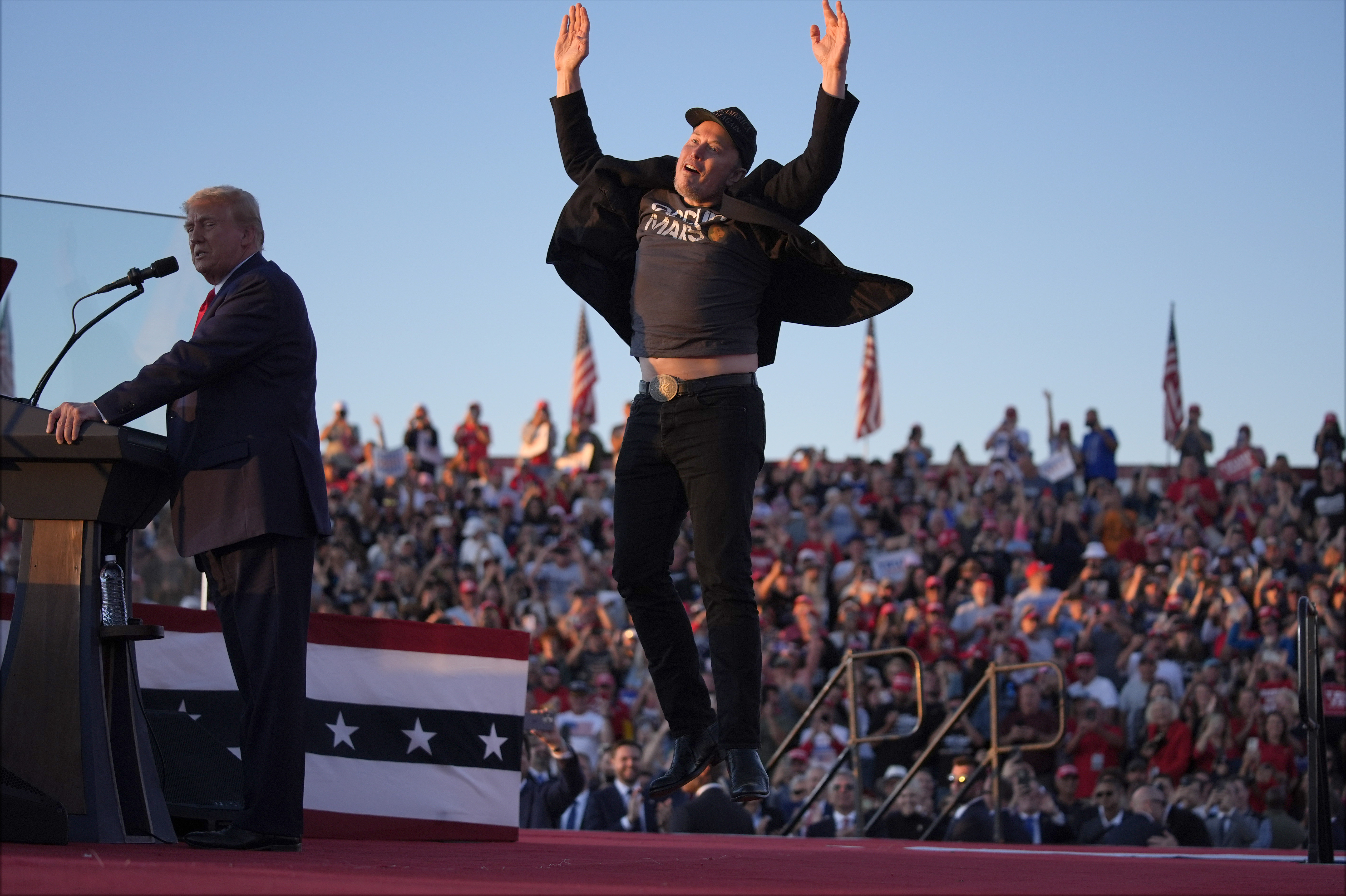 Elon Musk jumps on the stage as Republican presidential nominee former President Donald Trump speaks at a campaign rally at the Butler Farm Show, Saturday, Oct. 5, 2024, in Butler, Pa. (AP Photo/Evan Vucci)