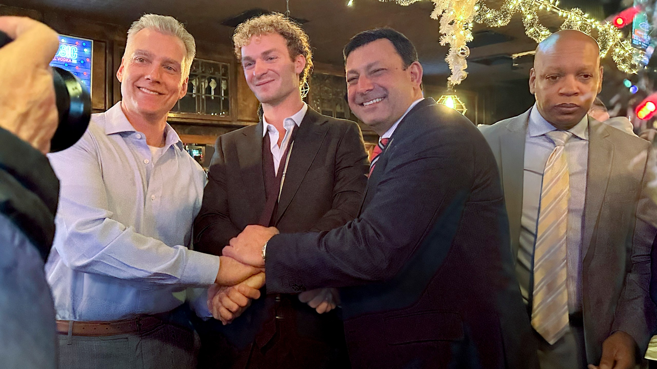 Daniel Penny, center, poses for a photo while gathered at a bar with his attorneys, Steven Raiser, left, and Thomas Kenniff after being acquitted of criminally negligent homicide, Monday, Dec. 9, 2024, in New York. (AP Photo/Jennifer Peltz)