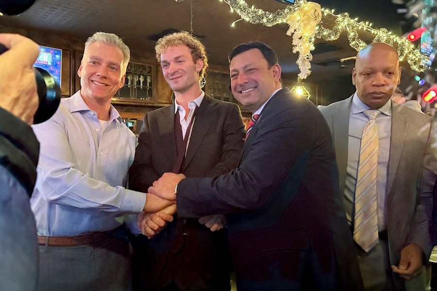 Daniel Penny, center, poses for a photo while gathered at a bar with his attorneys, Steven Raiser, left, and Thomas Kenniff after being acquitted of criminally negligent homicide, Monday, Dec. 9, 2024, in New York. (AP Photo/Jennifer Peltz)