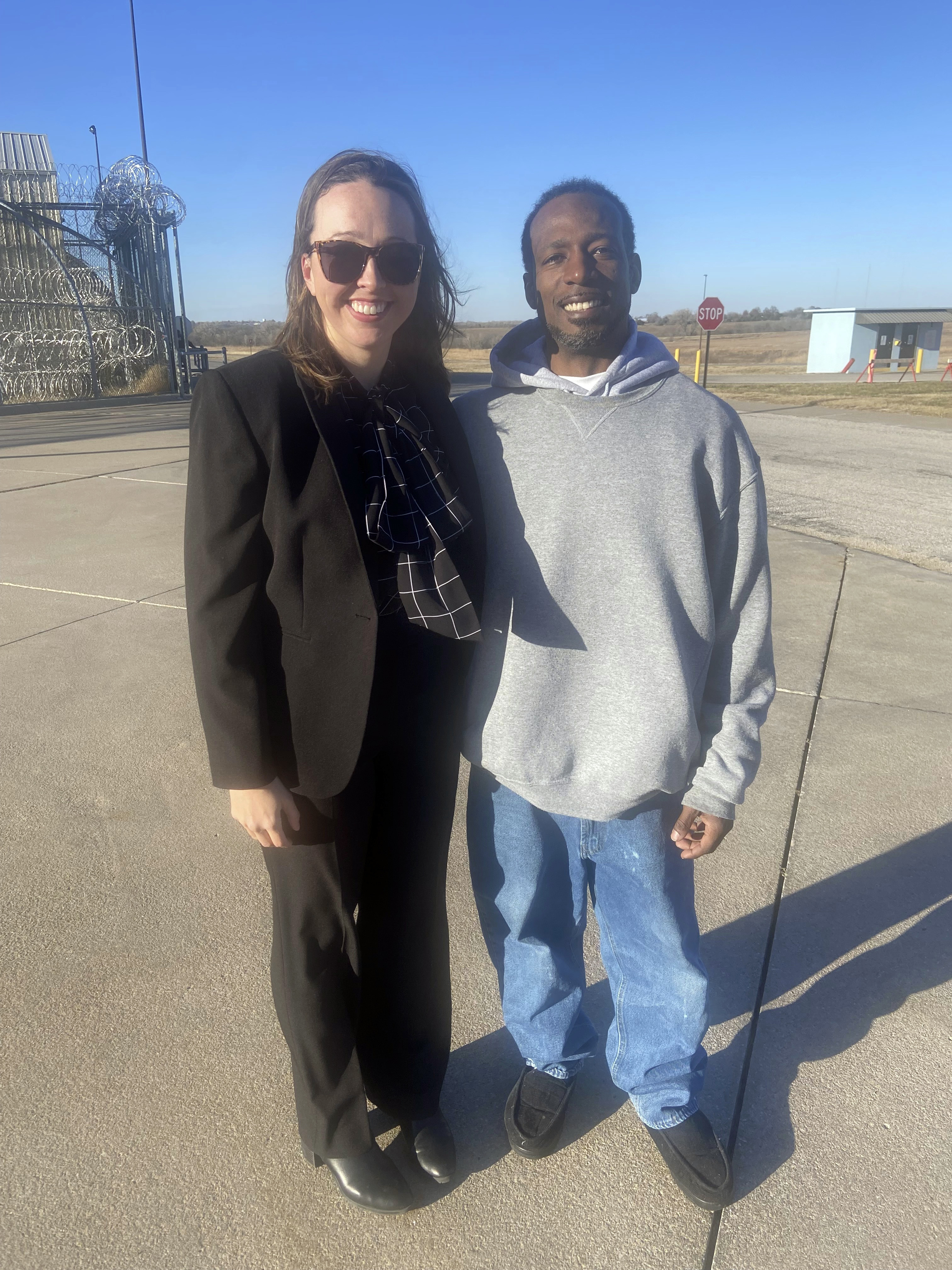 In this photo provided by Bob Hoffman, Dominique Moore, 40, poses with one of his attorneys, Courtney Stout, after he was released from prison when a judge overturned his conviction in a double homicide case, Wednesday, Dec. 11, 2024, in El Dorado, Kan. (Bob Hoffman via AP)