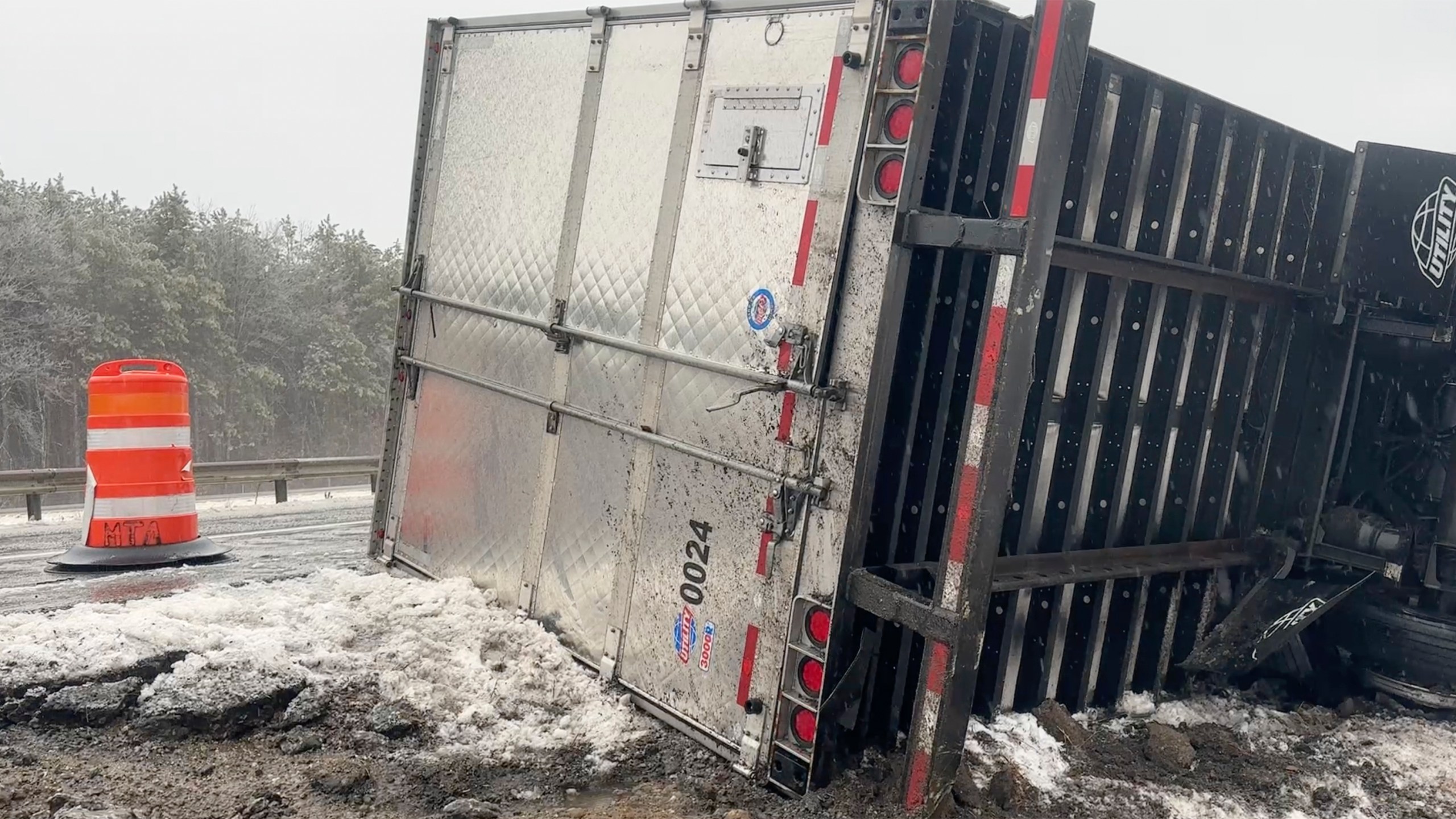 A tractor-trailer hauling a load of oranges sits on the side of the road after sliding off the Maine Turnpike early on Wednesday, Dec. 11, 2024, in New Gloucester, Maine. (AP Photo/David Sharp)