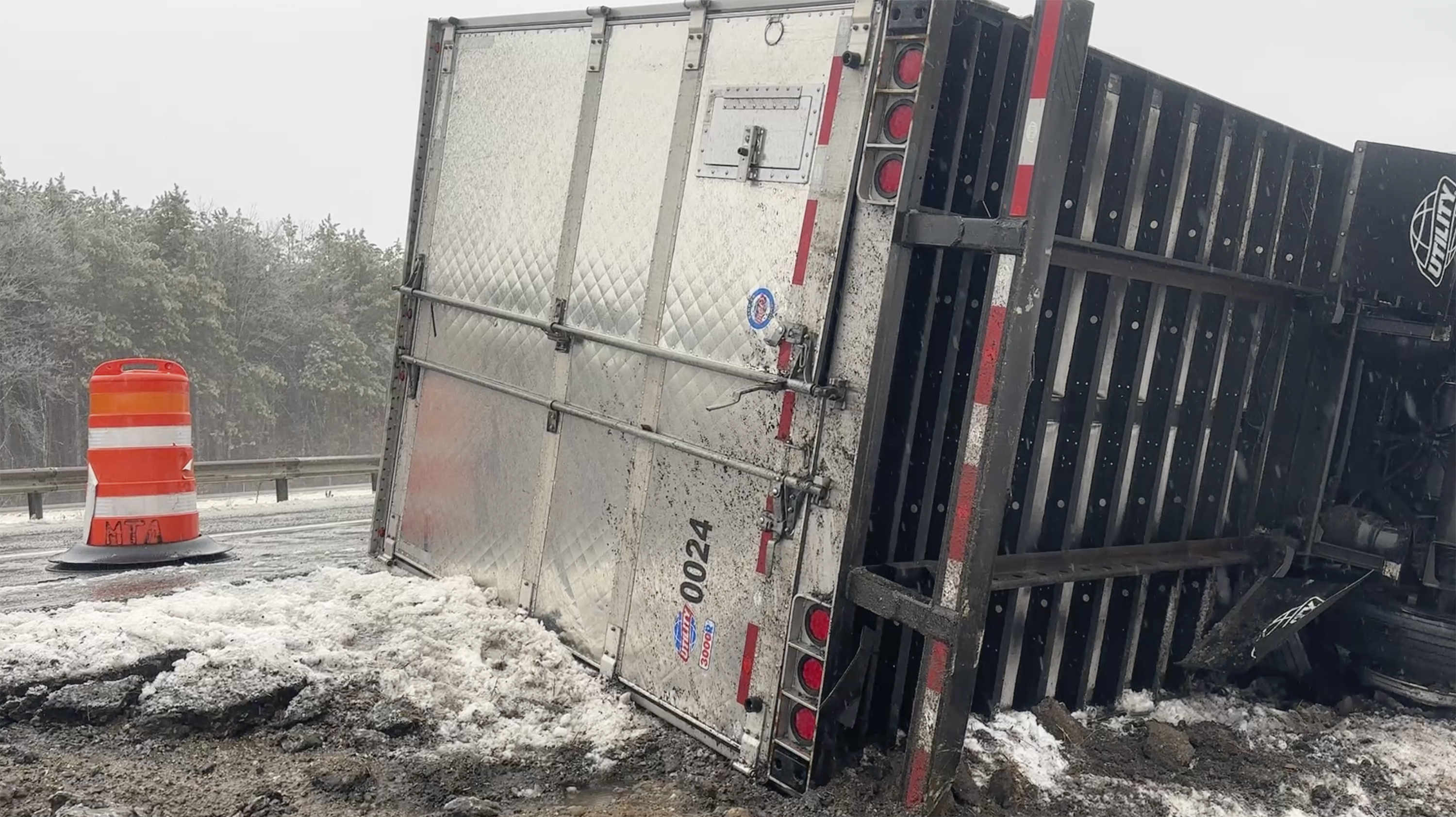 A tractor-trailer hauling a load of oranges sits on the side of the road after sliding off the Maine Turnpike early on Wednesday, Dec. 11, 2024, in New Gloucester, Maine. (AP Photo/David Sharp)