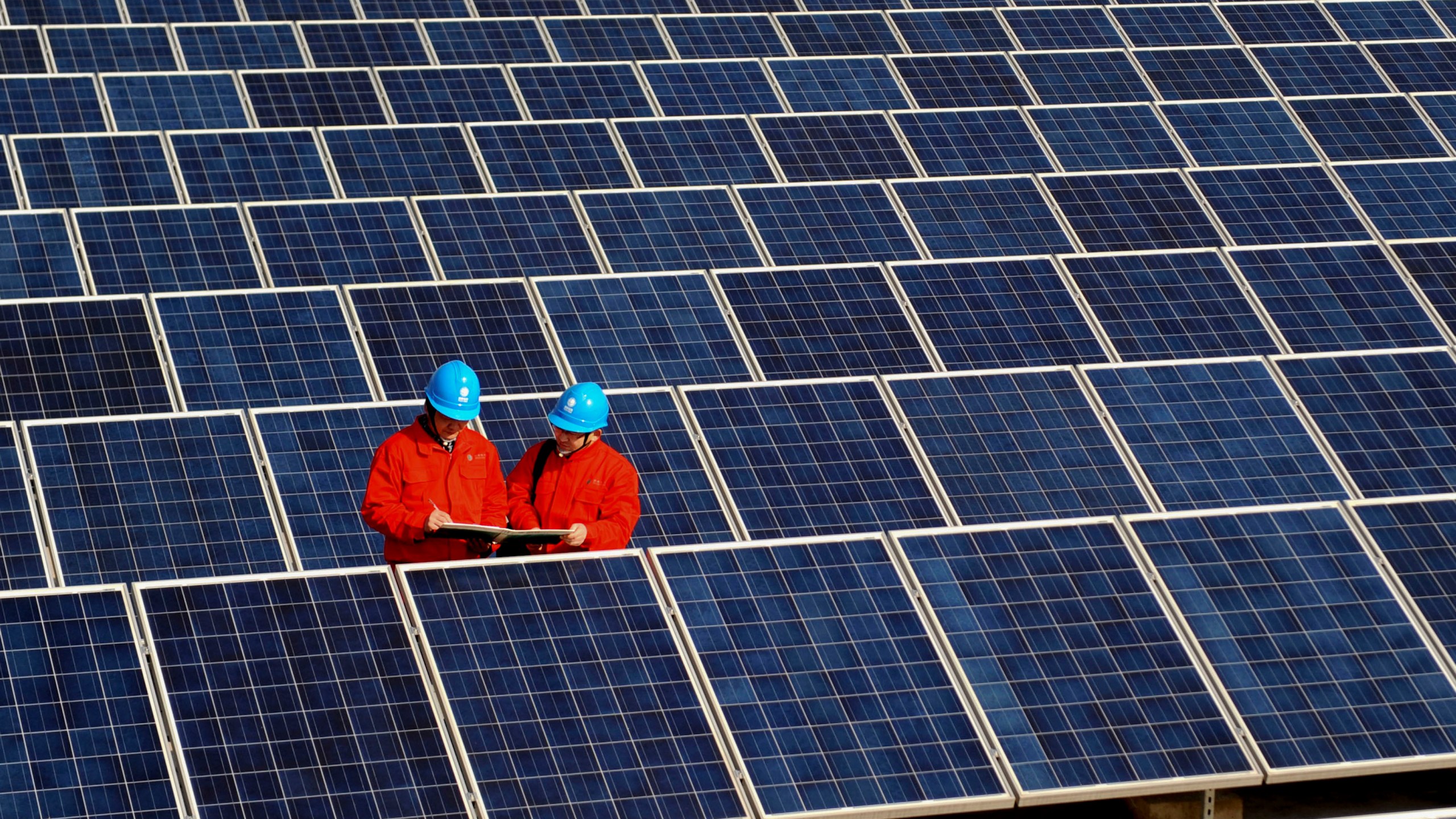 FILE - Workers check solar panels at a solar power station on a factory roof in Changxing, eastern China's Zhejiang province on Feb. 7, 2012. (AP Photo/File)