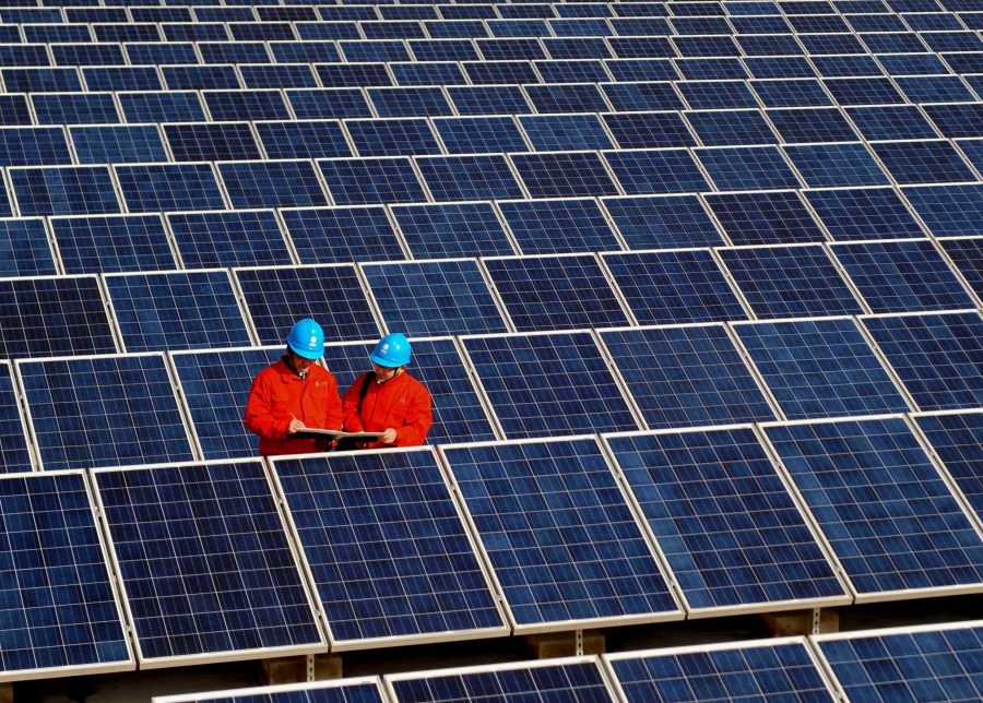 FILE - Workers check solar panels at a solar power station on a factory roof in Changxing, eastern China's Zhejiang province on Feb. 7, 2012. (AP Photo/File)