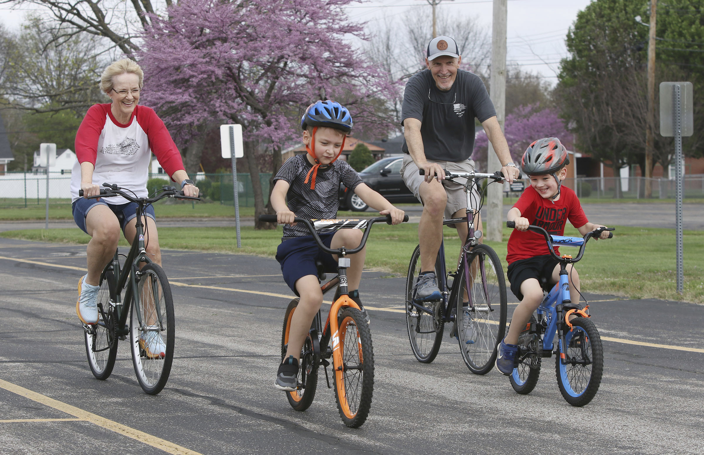 FILE - Gabriel Swift, 7, second left, wins a bike race against his brother, Isaiah Swift, 5, and his grandparents, Kim and Steve Swift, as they ride their bikes around the loop in the empty parking lot on Monday at One Faith Fellowship in the 1300 block of Tamarack in Owensboro, Ky., on April 1, 2024. (Alan Warren/The Messenger-Inquirer via AP)/The Messenger-Inquirer via AP, File)