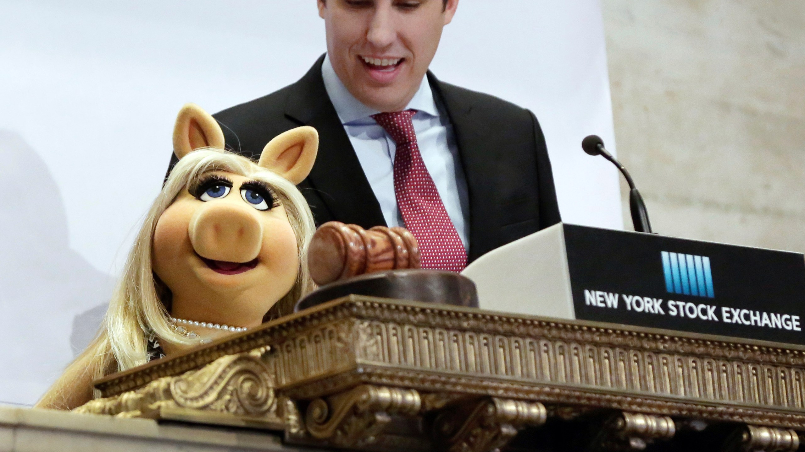 FILE - Miss Piggy, with New York Stock Exchange Chief of Staff John Tuttle, rings the NYSE opening bell to highlight the season premier of Disney's "The Muppets" television show, Feb. 1, 2016. (AP Photo/Richard Drew, File)