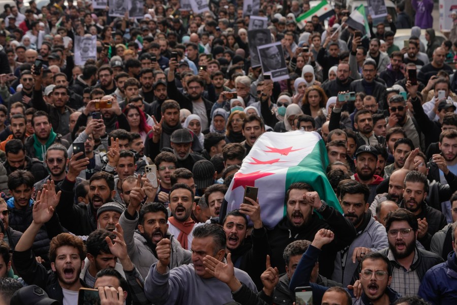 The coffin of Syrian activist Mazen al-Hamada is carried for burial in Damascus Thursday Dec. 12, 2024. Al-Hamad's mangled corpse was found wrapped in a bloody sheet in Saydnaya prison. He had fled to Europe but returned to Syria in 2020 and was imprisoned upon arrival. (AP Photo/Hussein Malla)