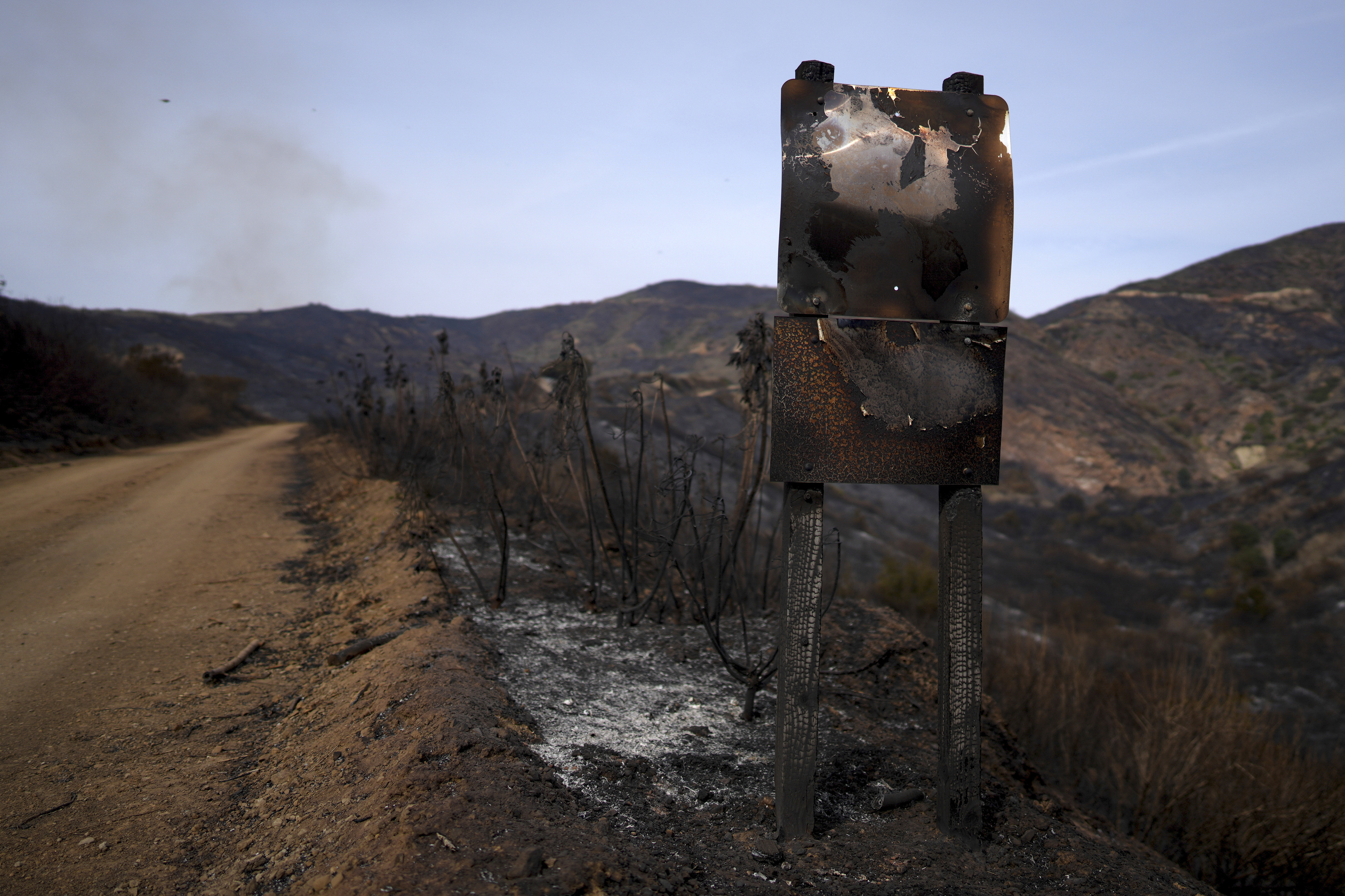 A road signed is burned after the Franklin Fire swept through Wednesday, Dec. 11, 2024, in Malibu, Calif. (AP Photo/Eric Thayer)