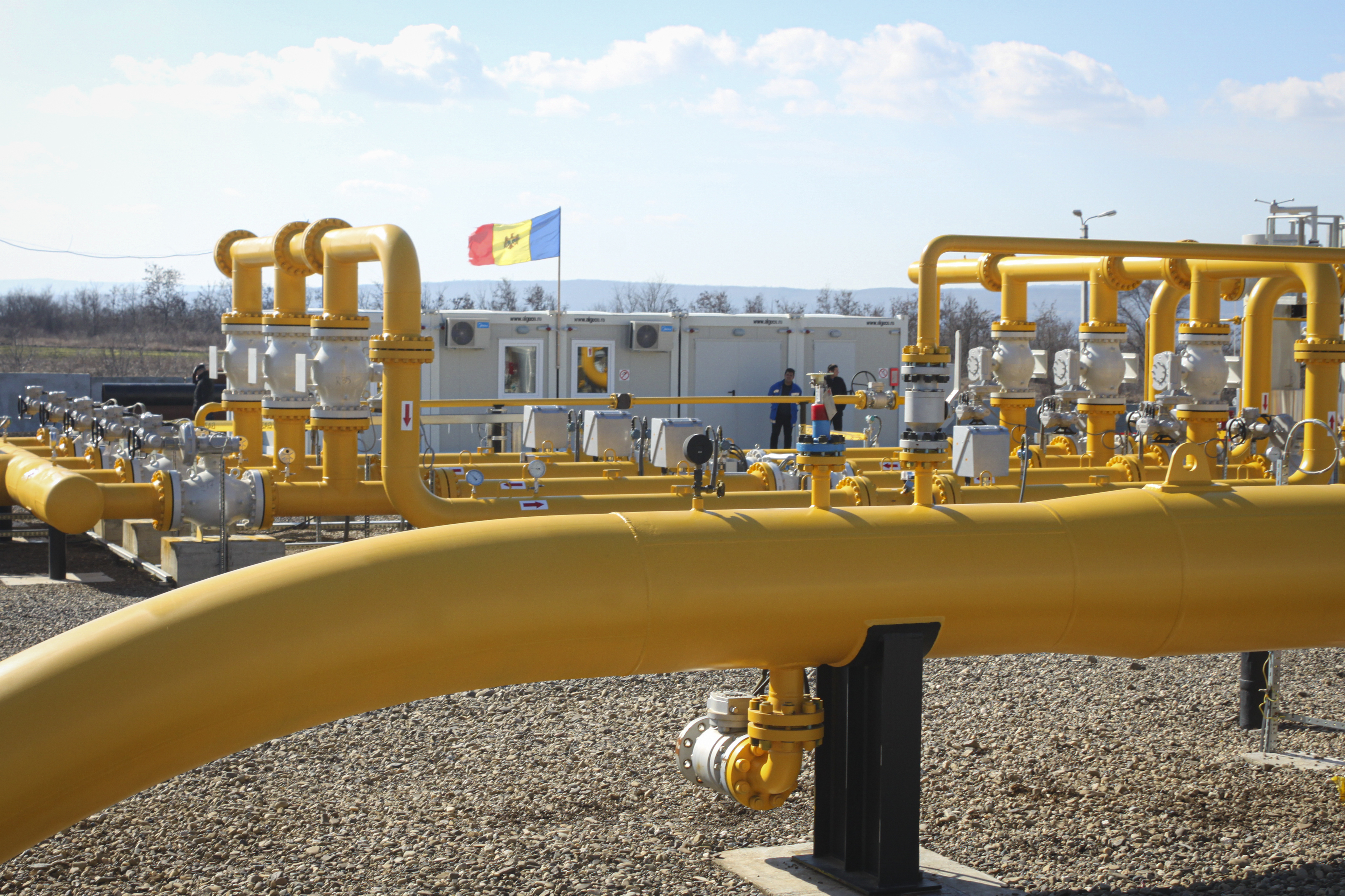 FILE - Men stand next to pipelines of the national natural gas distribution network outside Ungheni, Moldova, March 4, 2015. (AP Photo/Aurel Obreja)