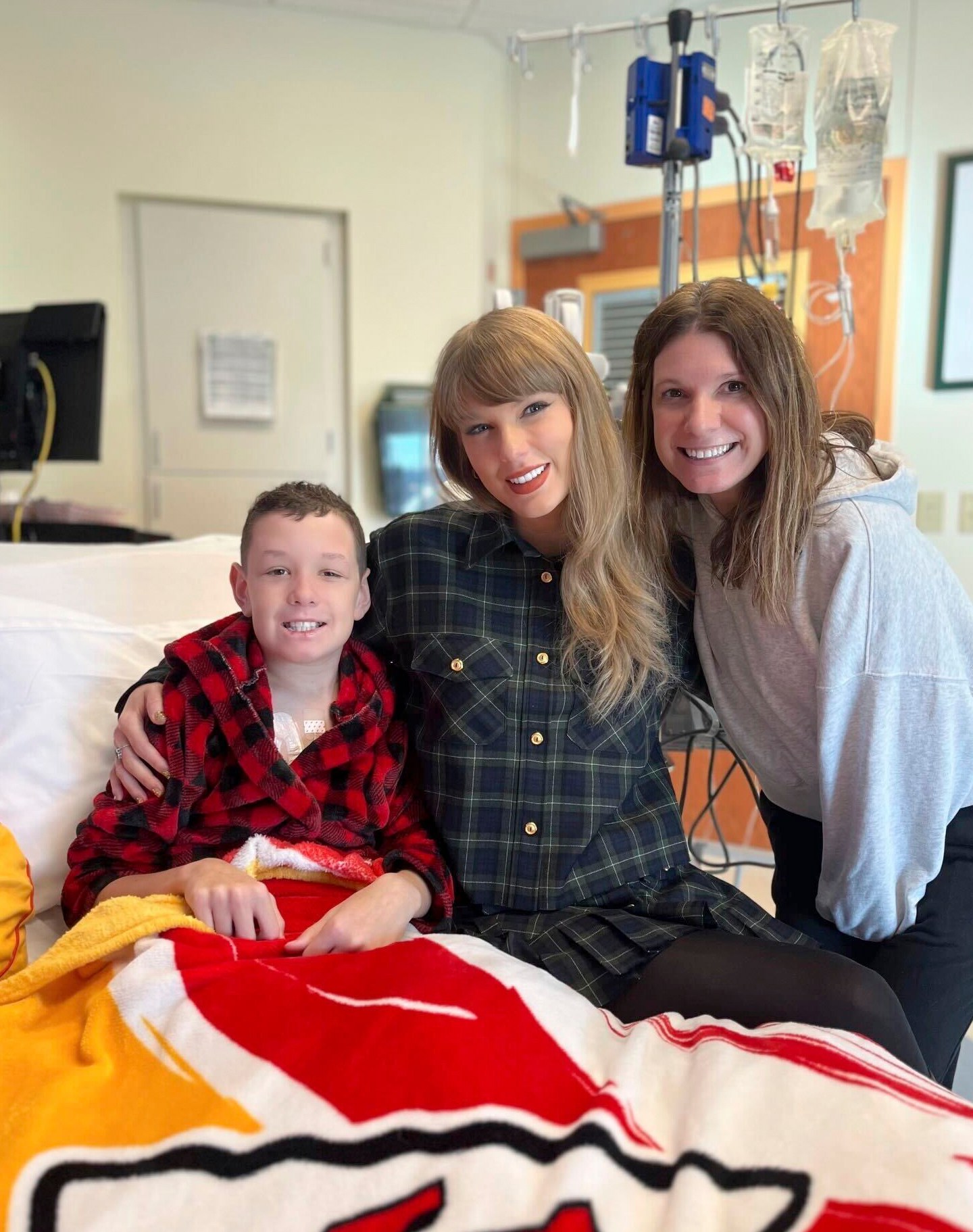 In this image provided by Cassie Thomas, Beckett Thomas, 13, who is a patient at Children's Mercy Hospital in Kansas City, Mo., and his mother Cassie Thomas, right, pose with Taylor Swift, Thursday, Dec. 12, 2024. (Cassie Thomas via AP)