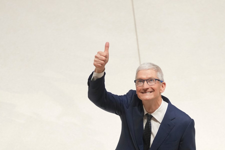 Apple CEO Tim Cook gestures as he accompanies Britain's King Charles III during a visit at Apple's UK Headquarters Battersea Power Station office in London, Thursday, Dec. 12, 2024. (AP Photo/Kin Cheung, Pool)