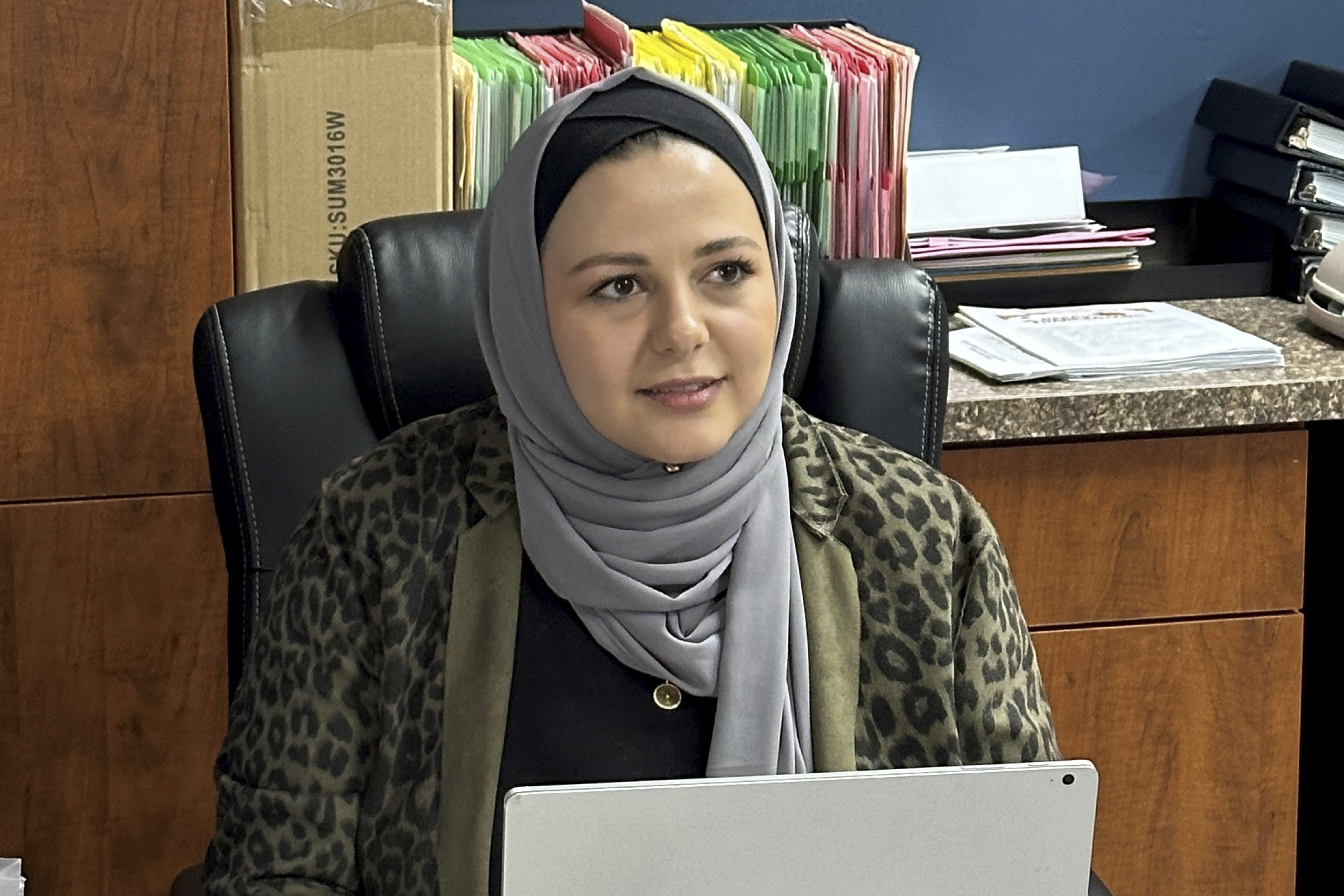 Rama Alhoussaini sits at her desk in Dearborn Heights, Mich., Tuesday, Dec. 10, 2024. (AP Photo/Corey Williams)