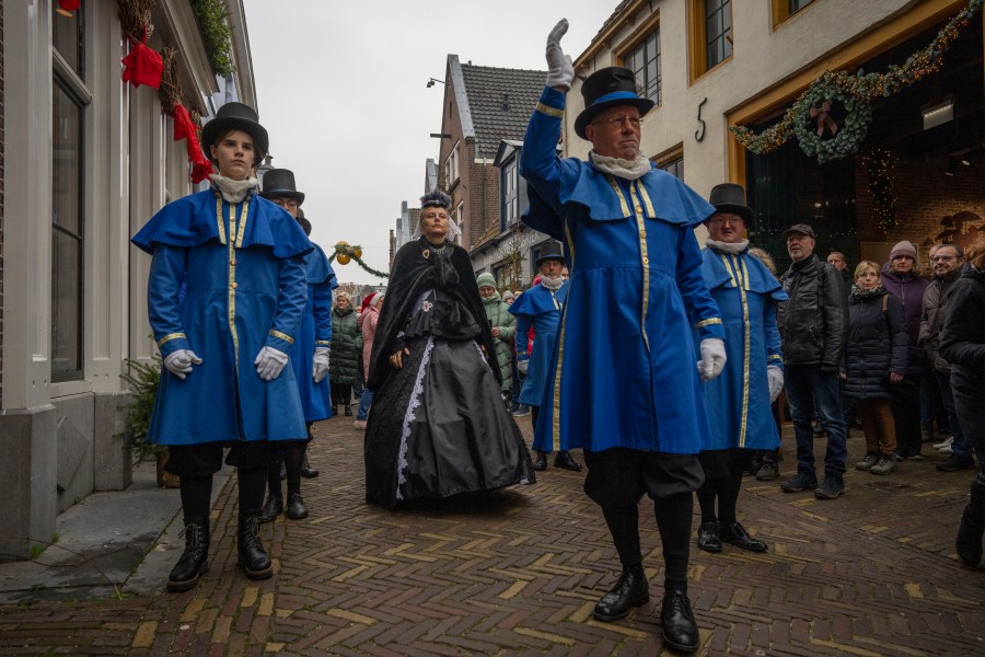 Sandra Nieland plays Queen Victoria a people in costumes from Charles Dickens' 19th-century English era take part in a Dickens Festival, in Deventer, Netherlands, Saturday, Dec. 14, 2024. (AP Photo/Peter Dejong)