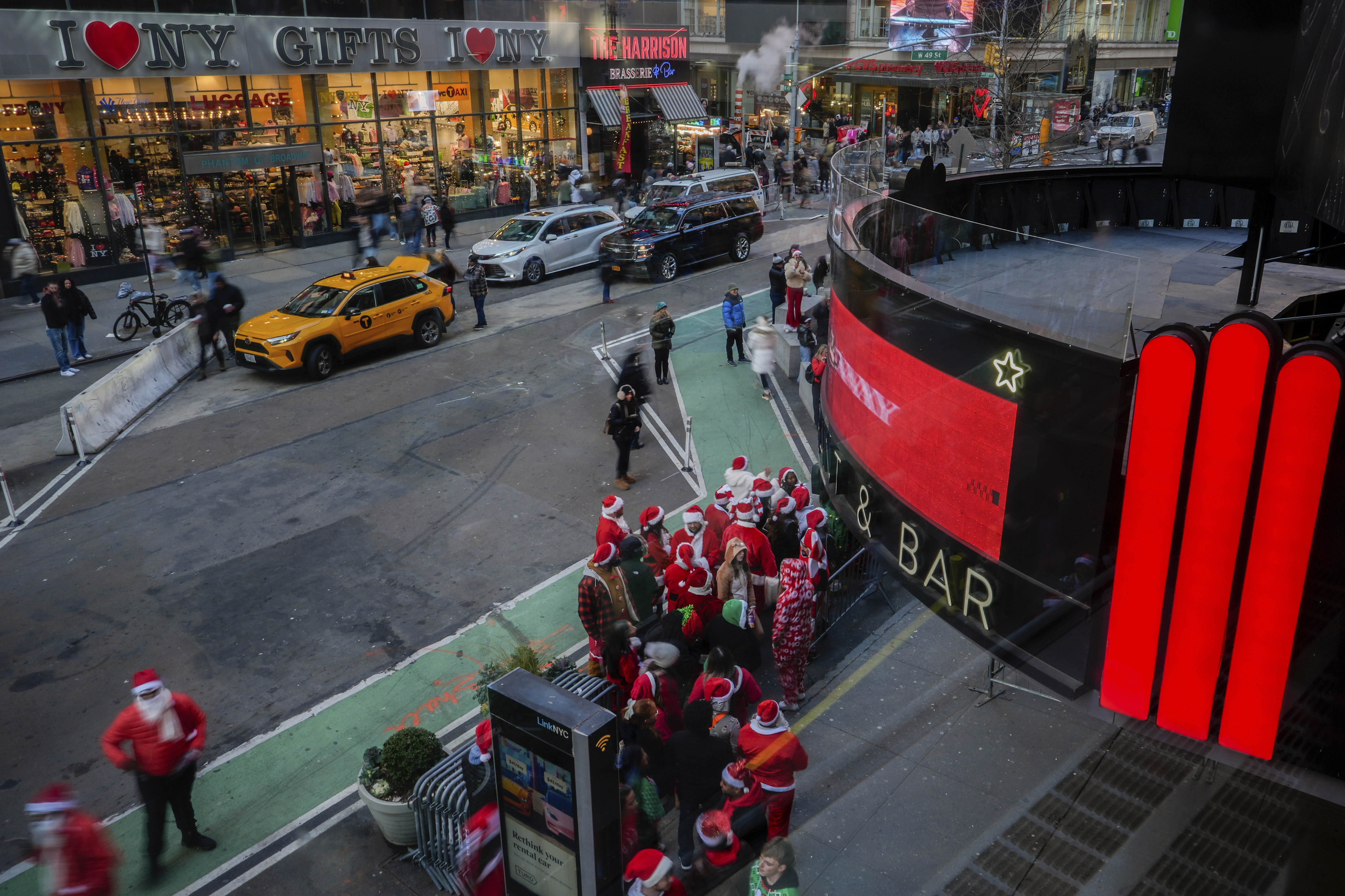 Revellers line up to enter a bar during SantaCon, Saturday, Dec. 14, 2024, in New York. (AP Photo/Julia Demaree Nikhinson)