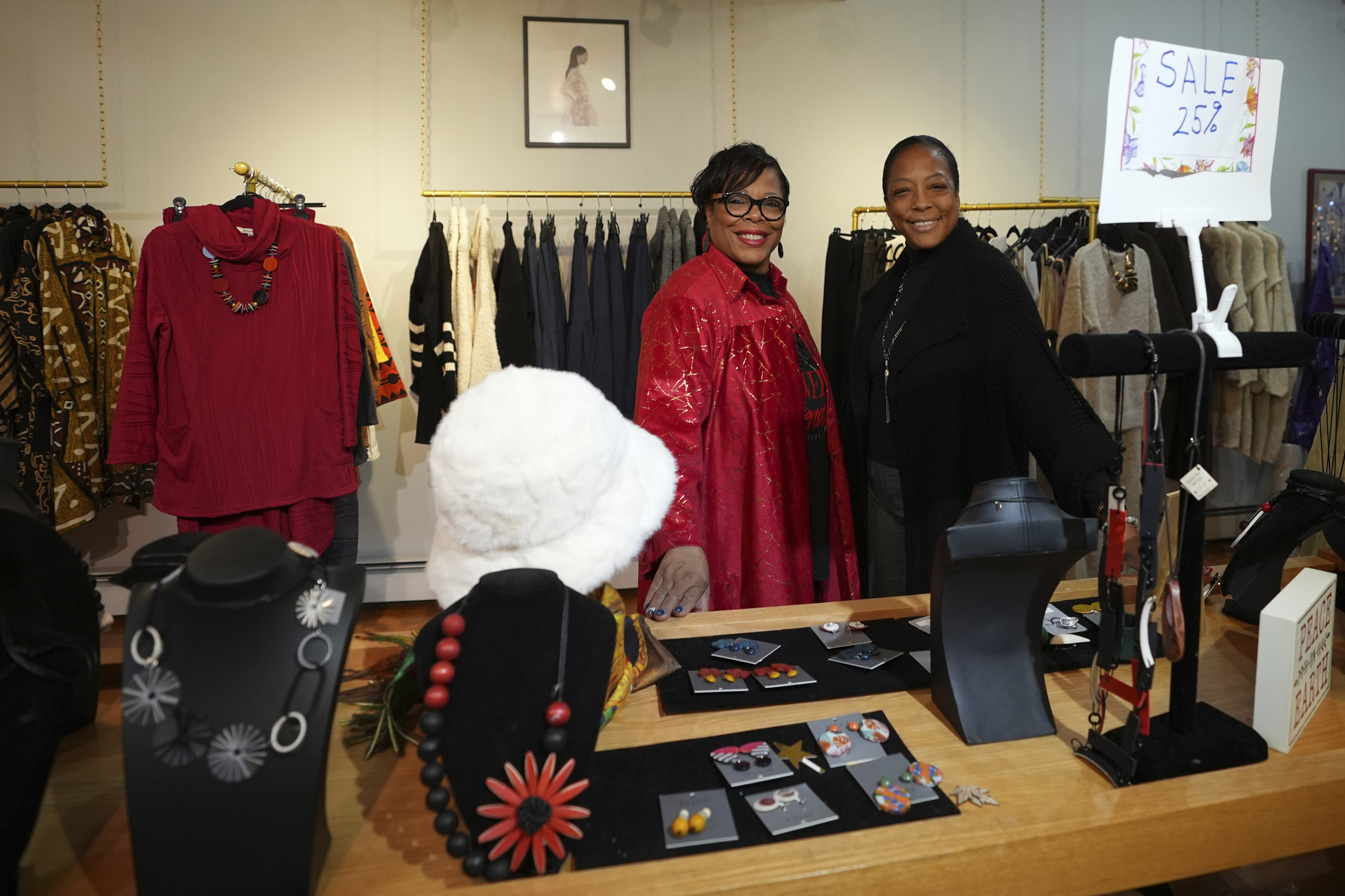 Claudia Averette, left, and her daughter, Atiya Smith pose for a photograph at their shop, Between Friends Boutique, Wednesday, Dec. 11, 2024, in Philadelphia. (AP Photo/Matt Slocum)