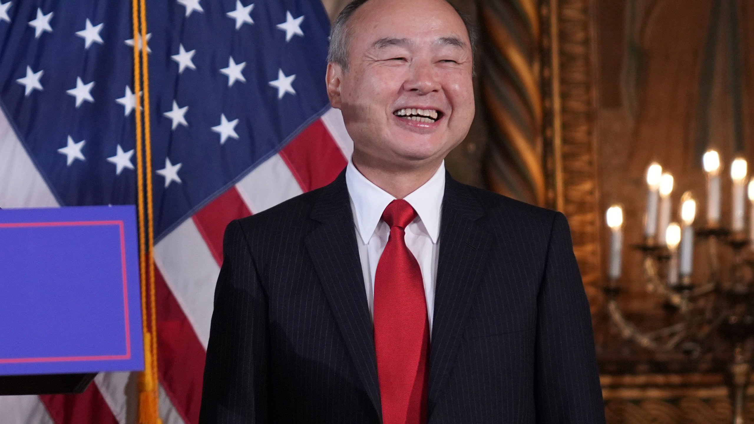 SoftBank Group CEO Masayoshi Son smiles as he listens to President-elect Donald Trump during a news conference at Mar-a-Lago, Monday, Dec. 16, 2024, in Palm Beach, Fla. (AP Photo/Evan Vucci)