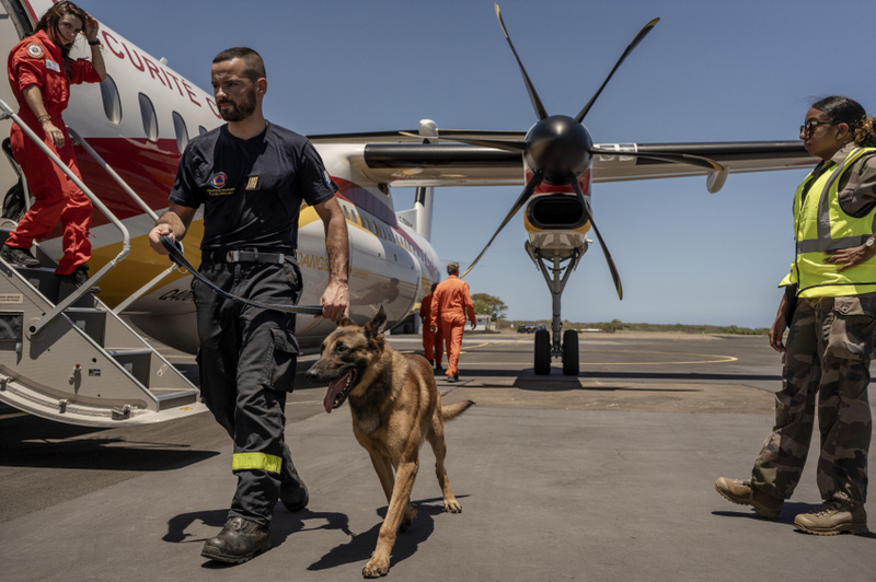 French civil security personnel board a flight to Mayotte from Saint Denis on Reunion Island, Tuesday, Dec. 17, 2024. (AP Photo/Adrienne Surprenant)