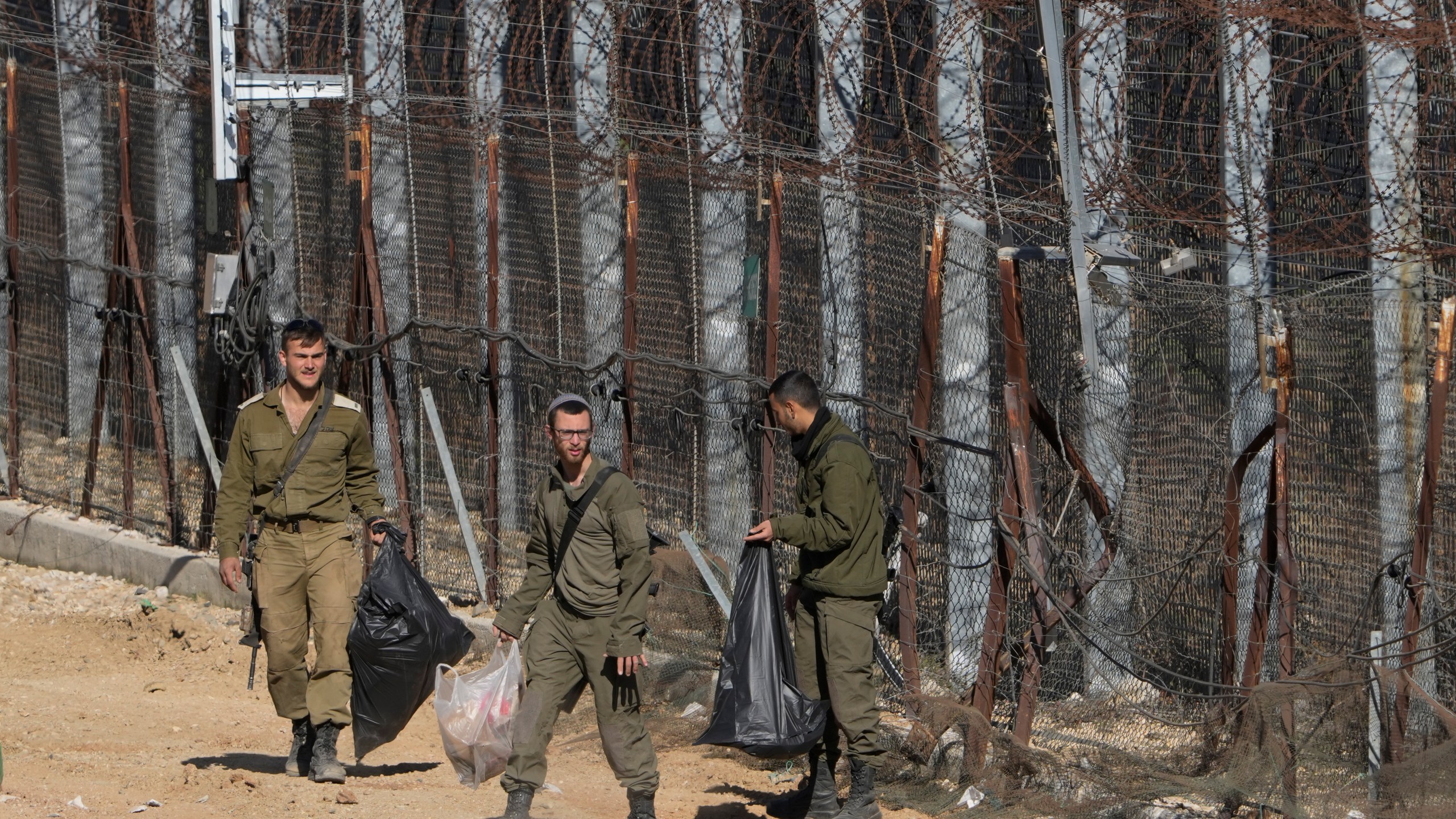 Israeli soldiers clean along the so-called Alpha Line that separates the Israeli-controlled Golan Heights from Syria, in the town of Majdal Shams, Tuesday, Dec. 17, 2024. (AP Photo/Matias Delacroix)