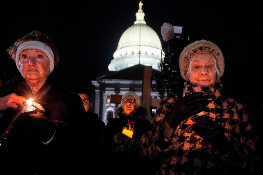 Supporters hold candles during a candlelight vigil Tuesday, Dec. 17, 2024, outside the Wisconsin Capitol in Madison, Wis., following a shooting at the Abundant Life Christian School on Monday, Dec. 16. (AP Photo/Morry Gash)