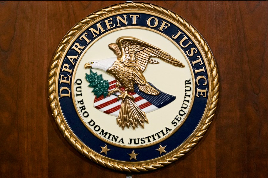 FILE - The seal of the Department of Justice is pictured, Aug. 1, 2023, in Washington. The U.S. government will pay nearly $116 million to resolve lawsuits brought by more than 100 women who say they were abused or mistreated at a now-shuttered federal prison in California that was known as the “rape club” because of rampant staff-on-inmate sexual misconduct. (AP Photo/J. Scott Applewhite, File)