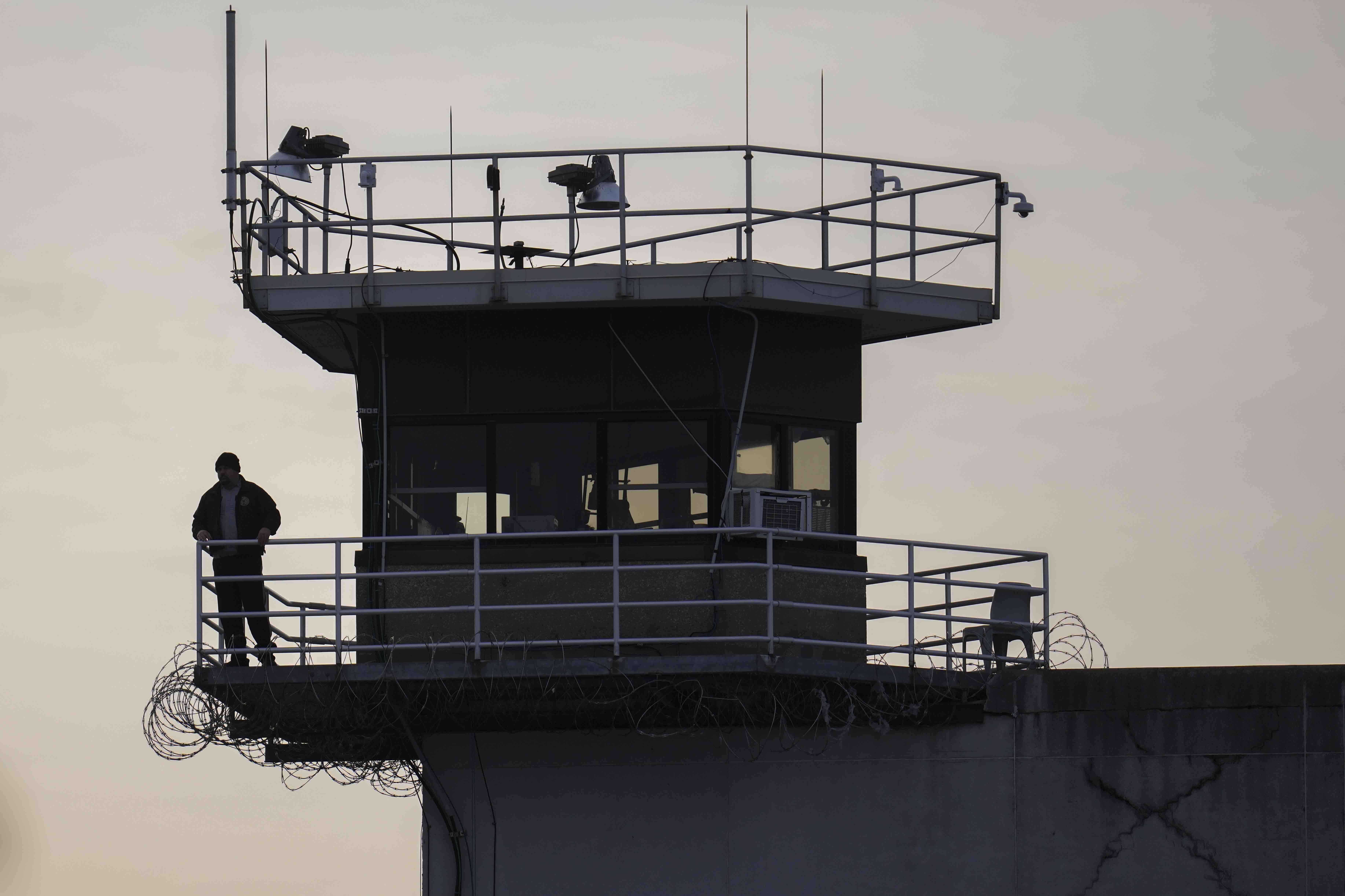 A guard stands in a tower at Indiana State Prison on Tuesday, Dec. 17, 2024, in Michigan City, Ind., where, barring last-minute court action or intervention by Gov. Eric Holcomb, Joseph Corcoran, 49, convicted in the 1997 killings of his brother and three other people, is scheduled to be put to death by lethal injection before sunrise Wednesday, Dec. 18. (AP Photo/Erin Hooley)