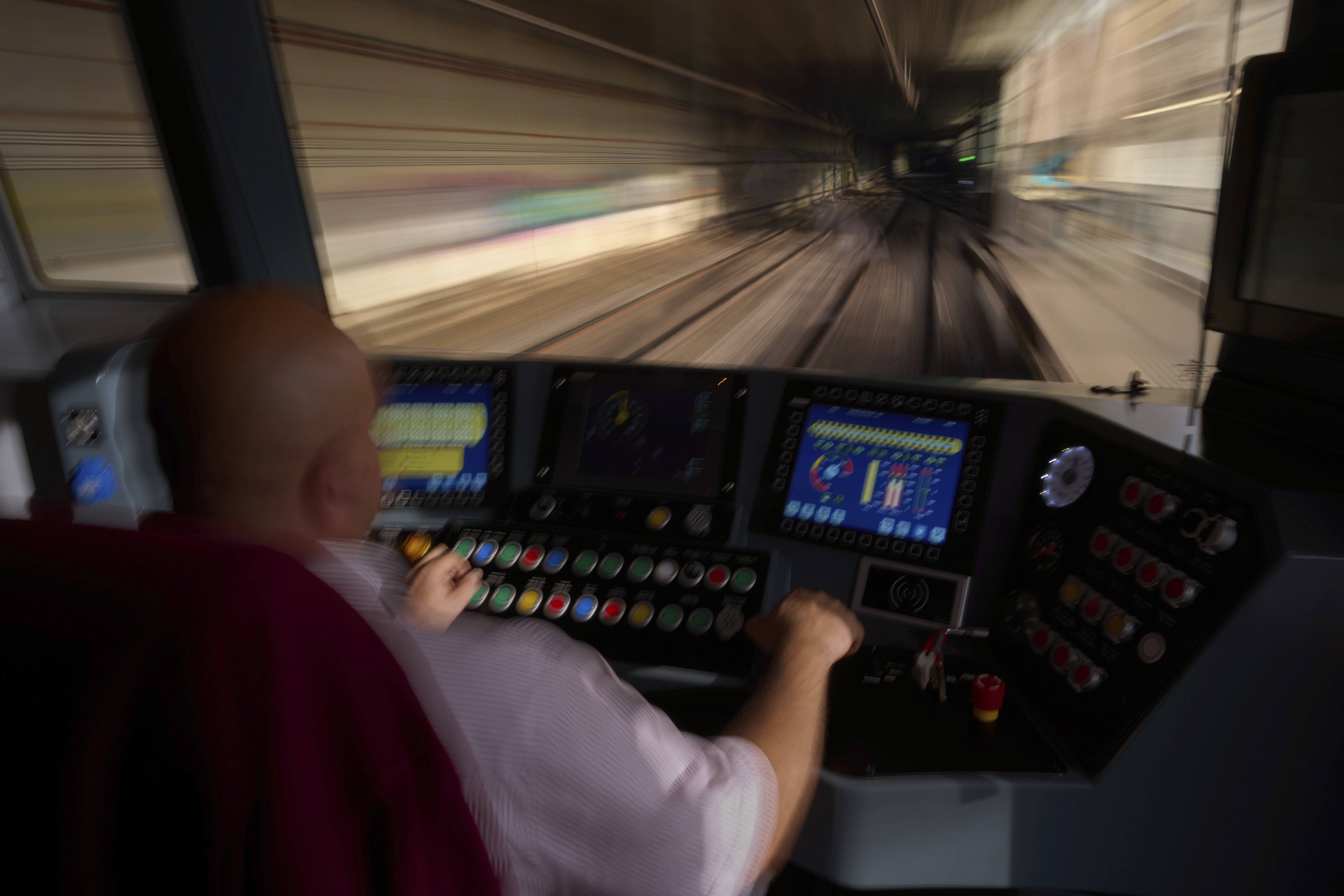 A subway driver operates the train's brake lever before entering a station in Barcelona, Spain, Monday, Dec. 2, 2024. (AP Photo/Emilio Morenatti)