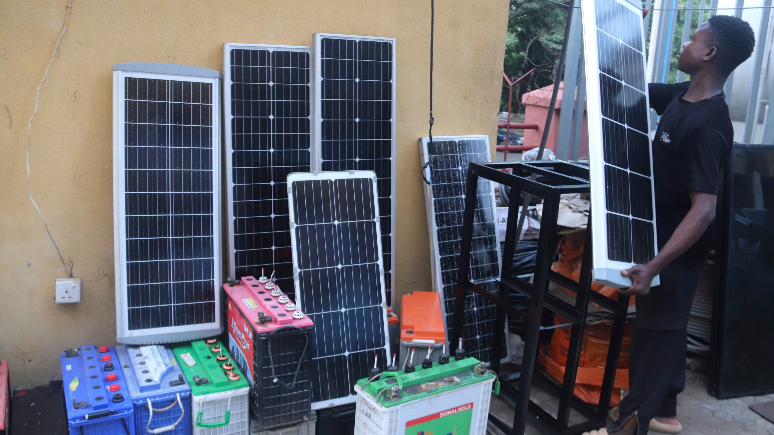 FILE - A man displays solar panels for sale outside a shop in Abuja, Nigeria, June 17, 2023. (AP Photo/Olamikan Gbemiga, File)