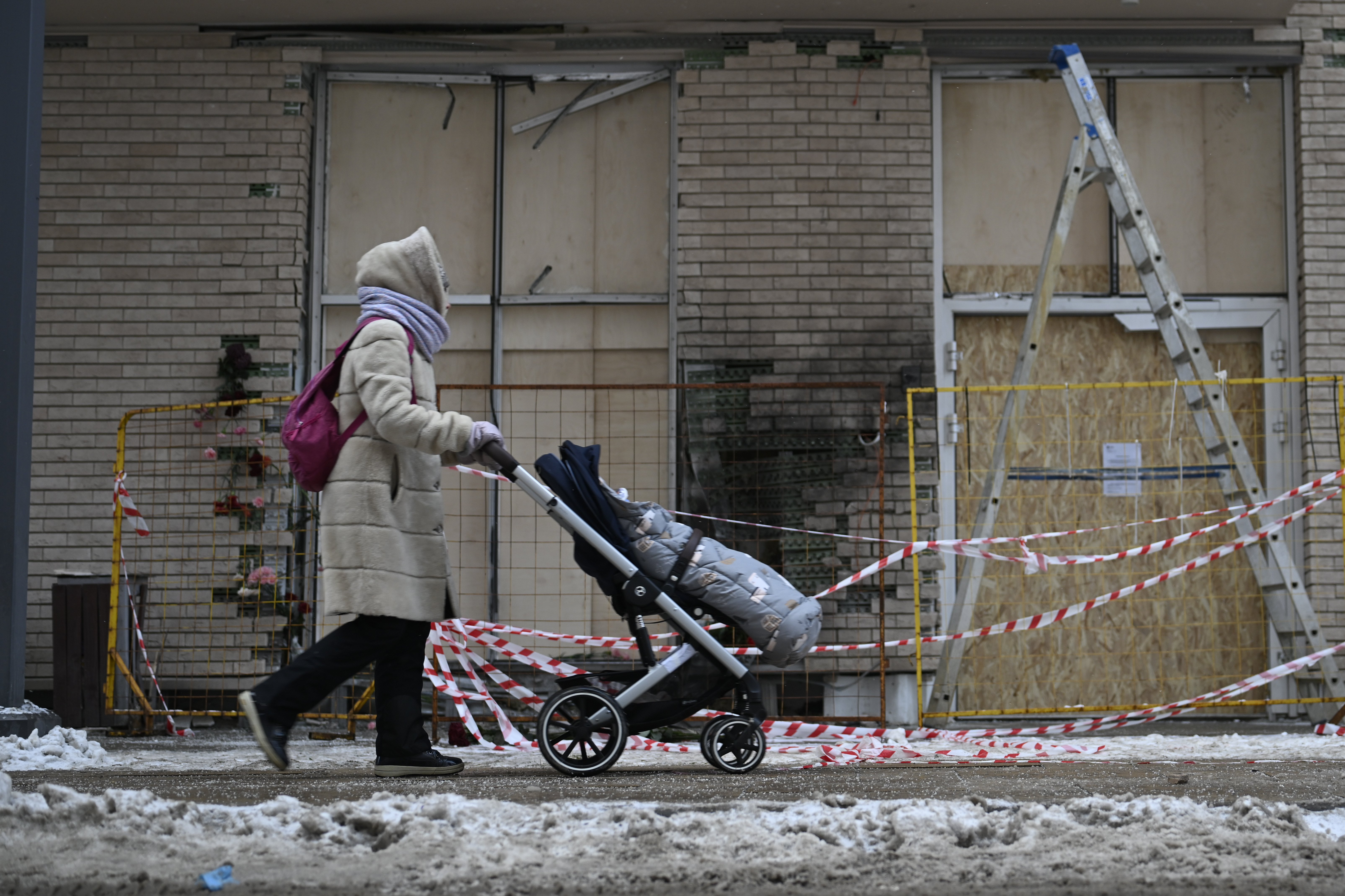 A person walks past an apartment block in Moscow, Russia, Wednesday, Dec. 18, 2024, where a bomb killed Lt. Gen. Igor Kirillov, head of Russia's Radiation, Biological and Chemical Defense Forces and his assistant, Ilya Polikarpov. (AP Photo/Dmitry Serebryakov)