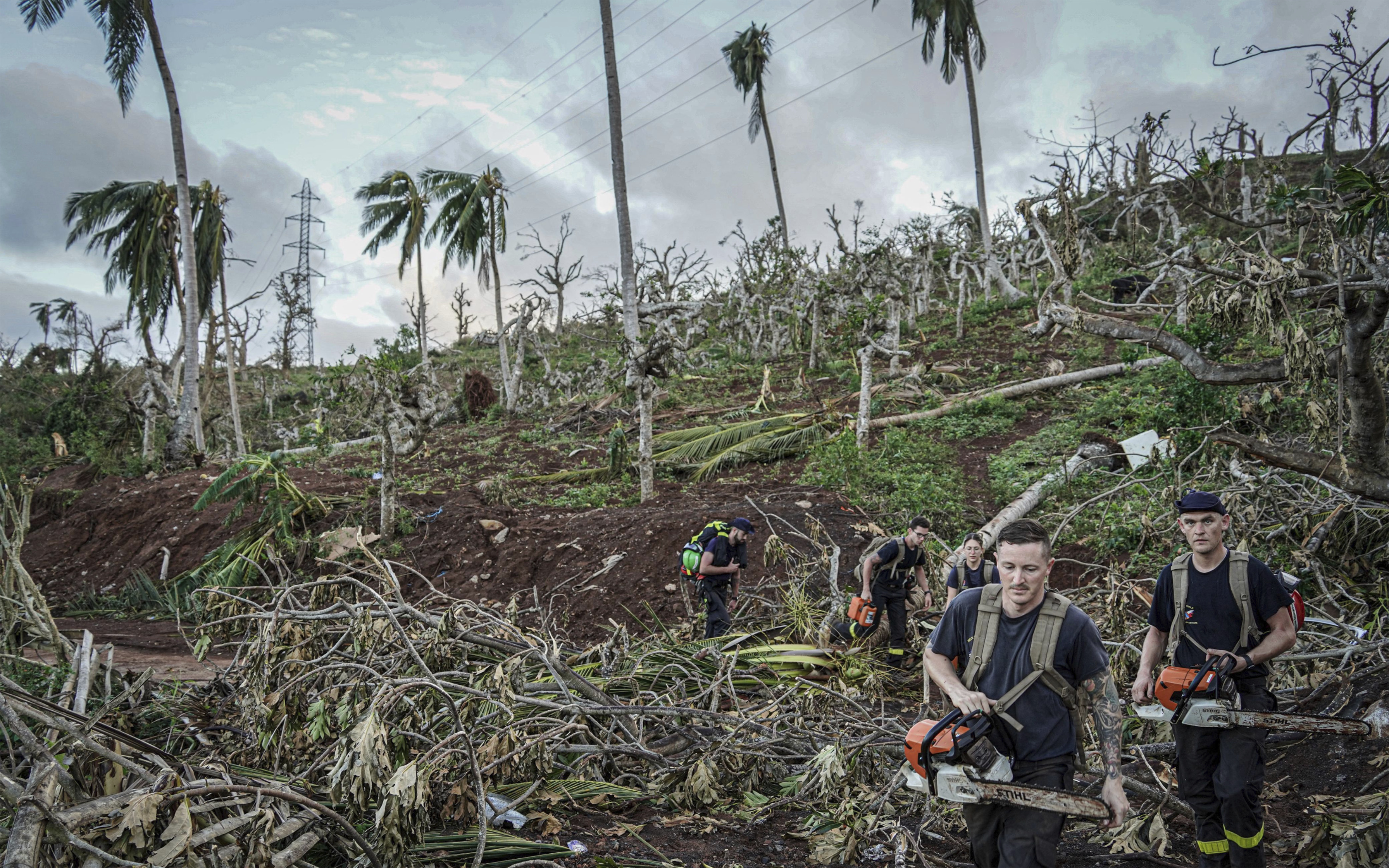 This photo provided by the French Interior Ministry shows rescue workers making their way in a devastated area of the French territory of Mayotte in the Indian Ocean, after the island was battered by its worst cyclone in nearly a century, Tuesday Dec. 17, 2024. (Ministere de l'Interieur/Securite Civile via AP)