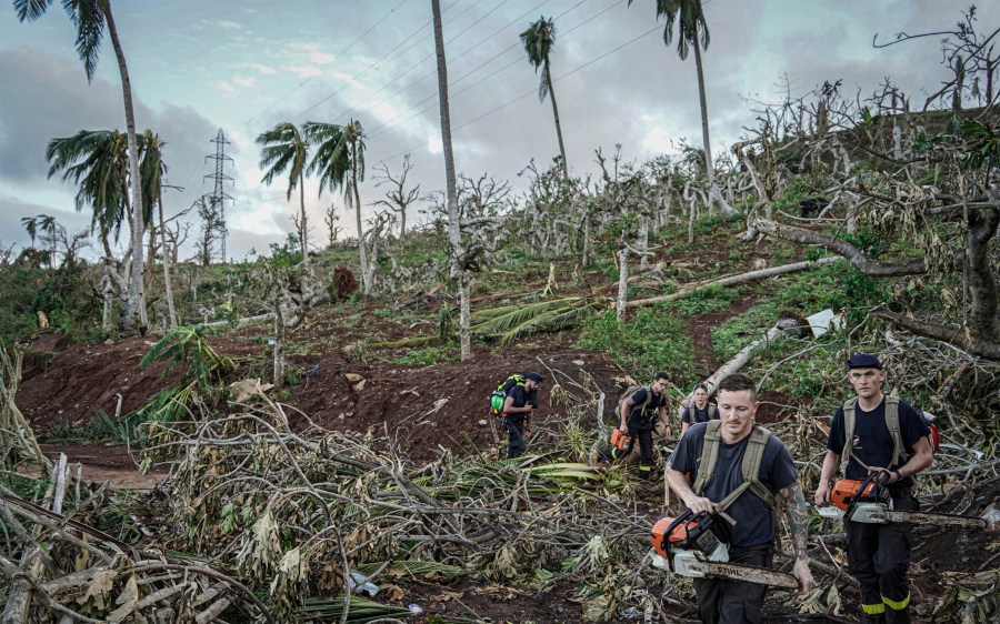 This photo provided by the French Interior Ministry shows rescue workers making their way in a devastated area of the French territory of Mayotte in the Indian Ocean, after the island was battered by its worst cyclone in nearly a century, Tuesday Dec. 17, 2024. (Ministere de l'Interieur/Securite Civile via AP)