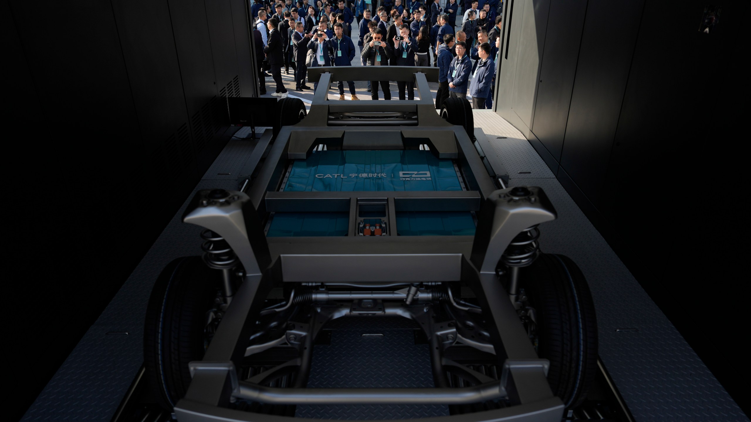 Attendees look at the next generation battery swapping station from China-based CATL, the world's largest maker of batteries for electric vehicles, before a launch presentation held in Xiamen, southern China's Fujian province on Wednesday, Dec. 18, 2024. (AP Photo/Ng Han Guan)