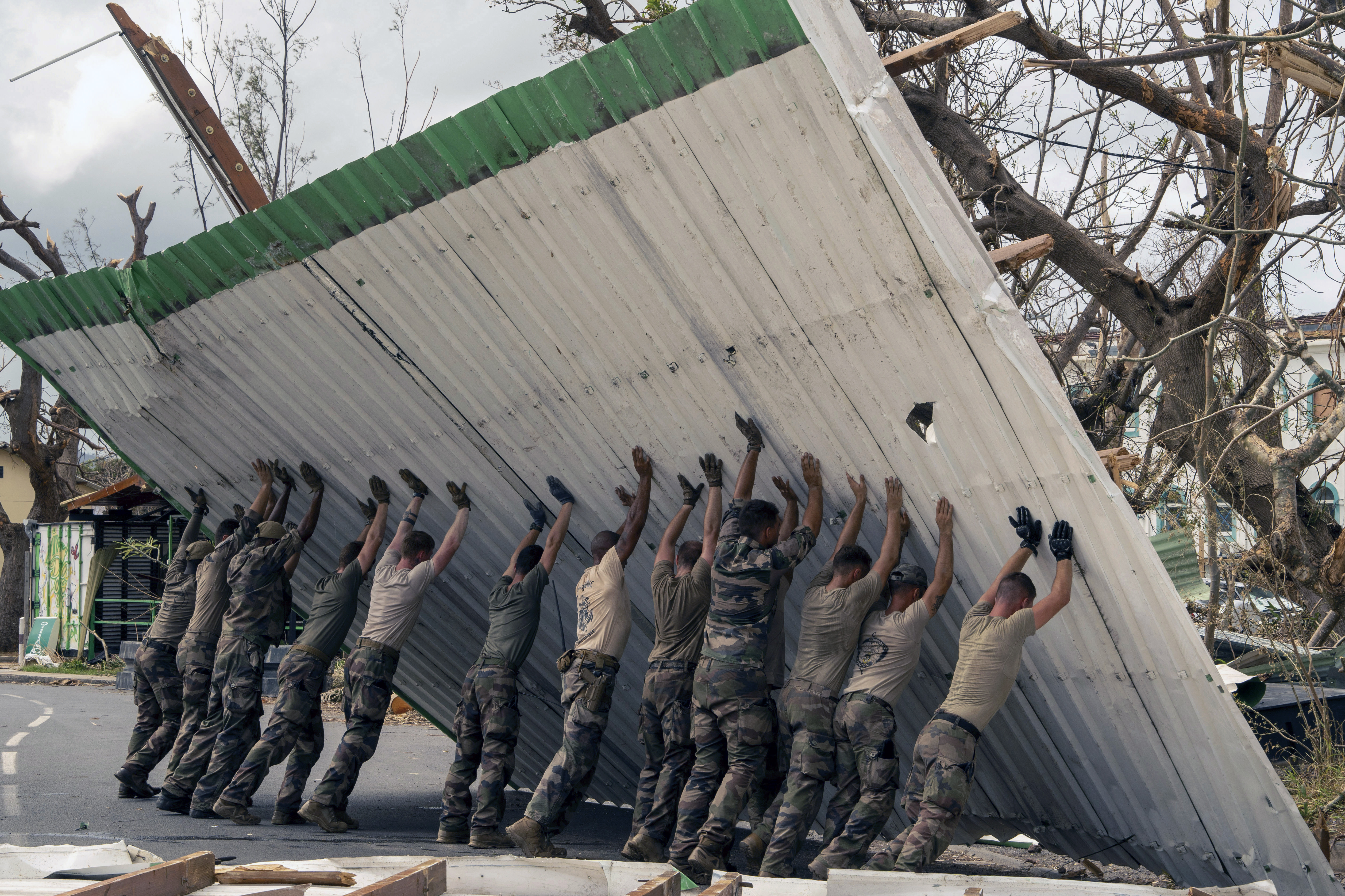 This photo provided by the French Army shows soldiers lifting a collapsed barrier in the Indian Ocean French territory of Mayotte, Wednesday Dec.18, 2024, as the cyclone on Saturday was the deadliest storm to strike the territory in nearly a century. (D Piatacrrea, Etat Major des Armees/Legion Etrangere via AP)