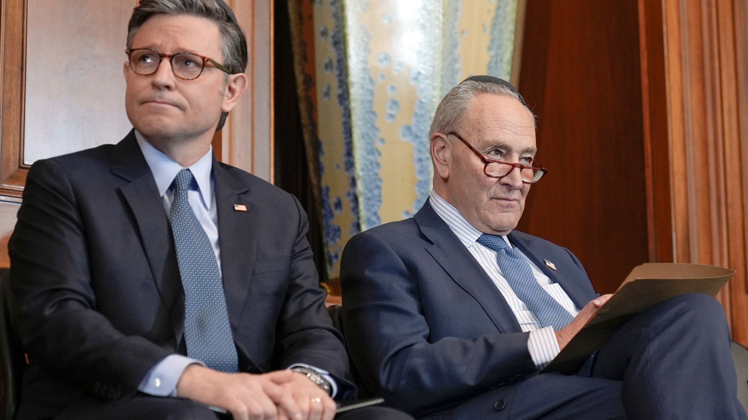 Senate Majority Leader Chuck Schumer, D-N.Y., right and Speaker of the House Mike Johnson, R-La., left, are listen during a U.S. Capitol Hanukkah event with a ceremonial Menorah lighting to commemorate the upcoming eight-day festival of Hanukkah on Capitol Hill Tuesday, Dec. 17, 2024, in Washington. (AP Photo/Mariam Zuhaib)