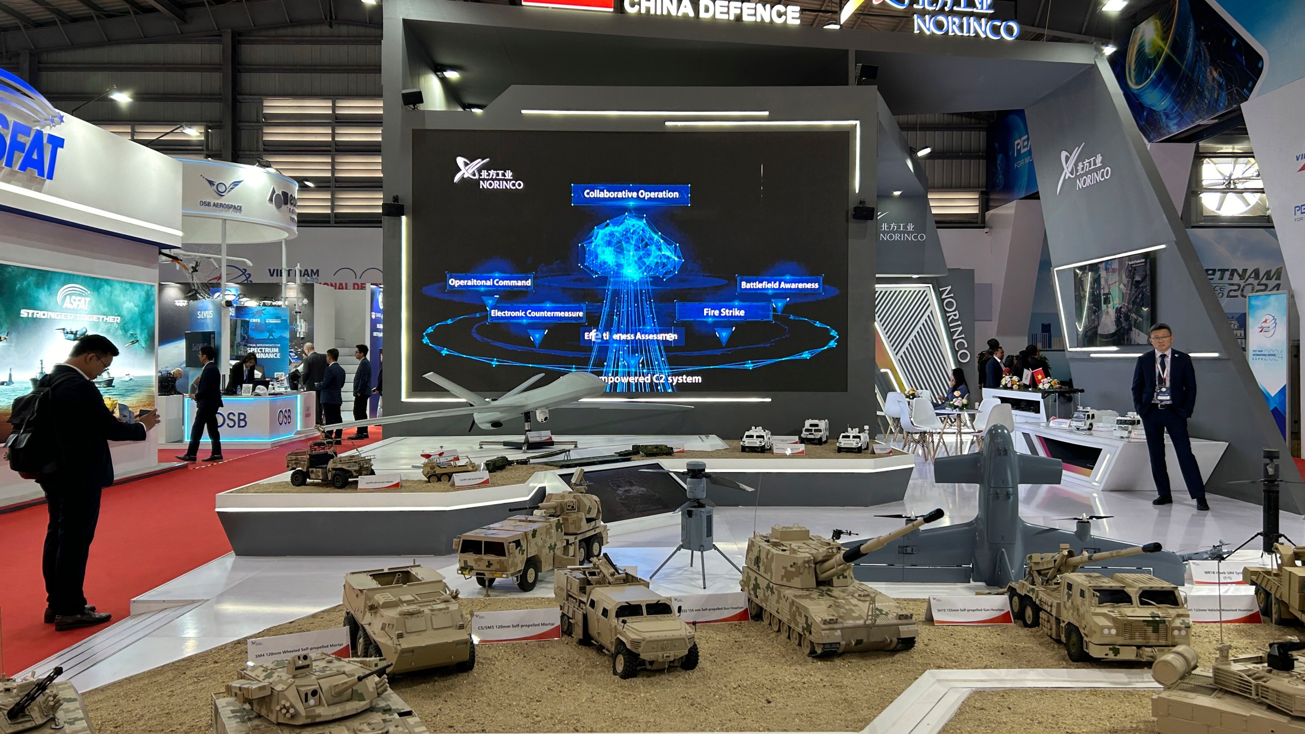 A man takes a photograph of China's NORINCO stall at the Vietnam International Defense Expo held in Hanoi, Vietnam, Thursday, Dec.19, 2024. (AP Photo/Aniruddha Ghosal)