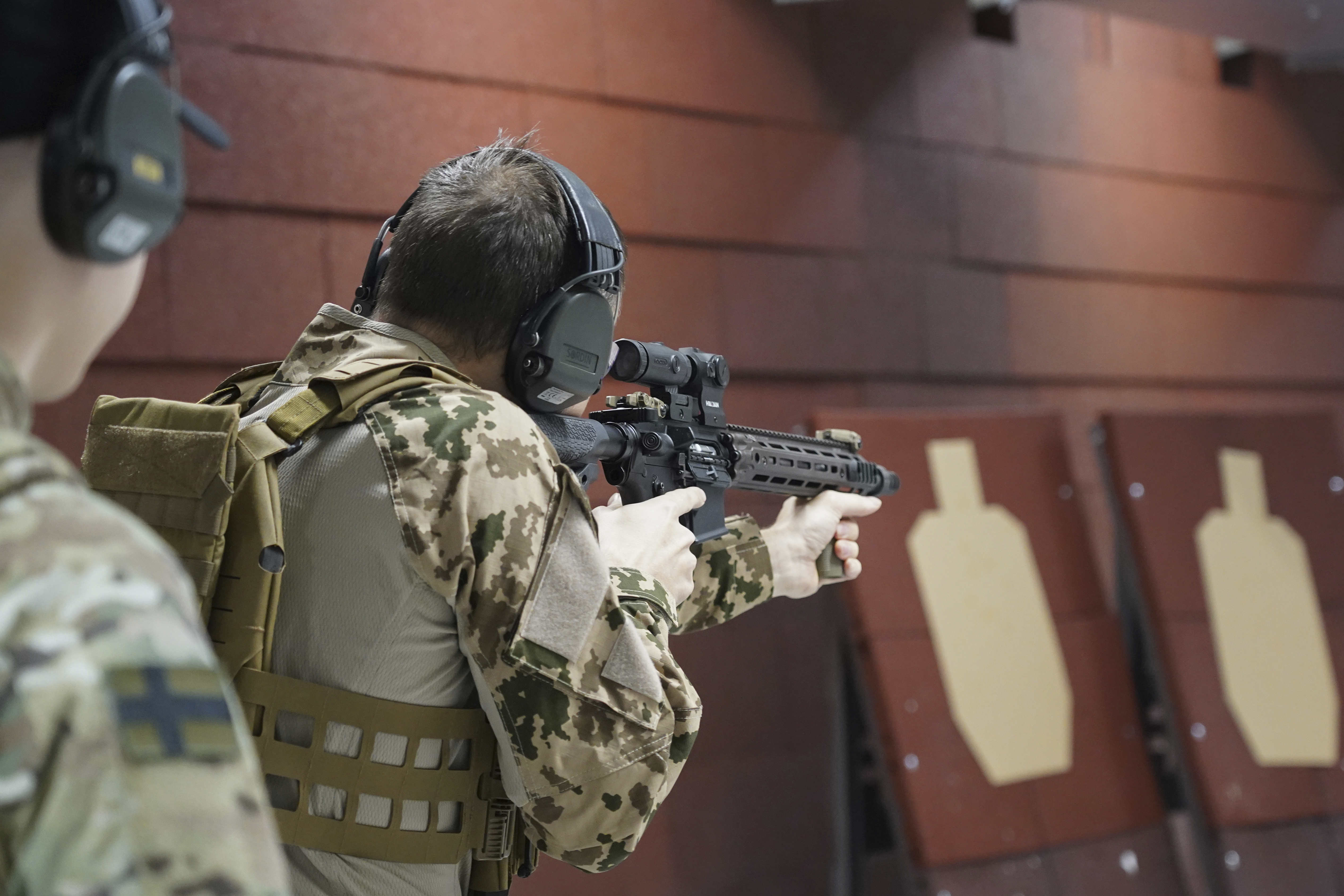 Members of the Vantaa Reservists Association practice at a shooting range in a warehouse in Kerava on the outskirts of Helsinki, Finland, Monday, Dec. 2, 2024. (AP Photo/James Brooks)