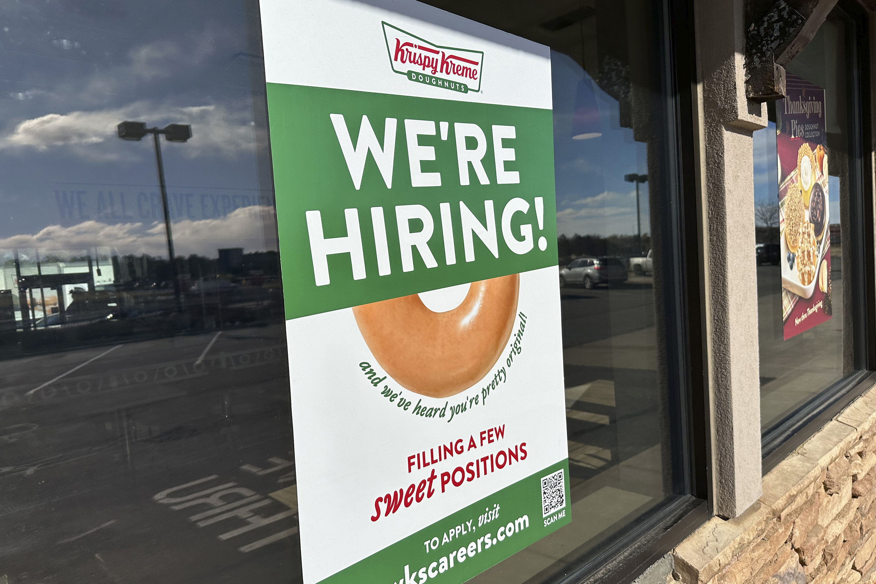 FILE - A hiring sign is displayed in the window of a Krispy Kreme donut shop on Nov. 19, 2024, in Lone Tree, Colo. (AP Photo/David Zalubowski, File)