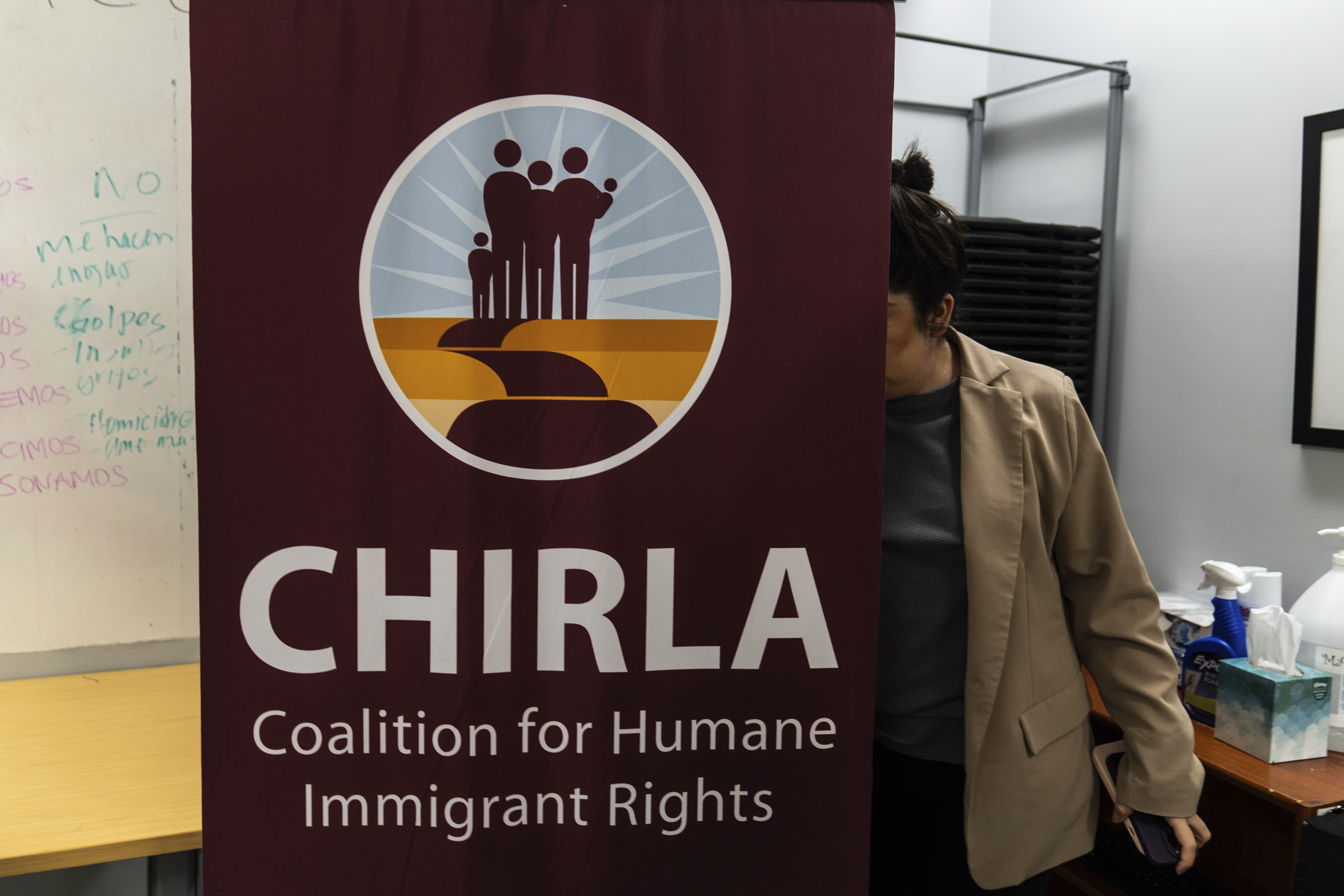 Elizabeth Rodriguez, digital content creator at the Coalition for Humane Immigrant Rights, sets up a banner for a bilingual workshop for immigrants who want to stay in the United States in Los Angeles, Wednesday, Dec. 4, 2024. (AP Photo/Jae C. Hong)