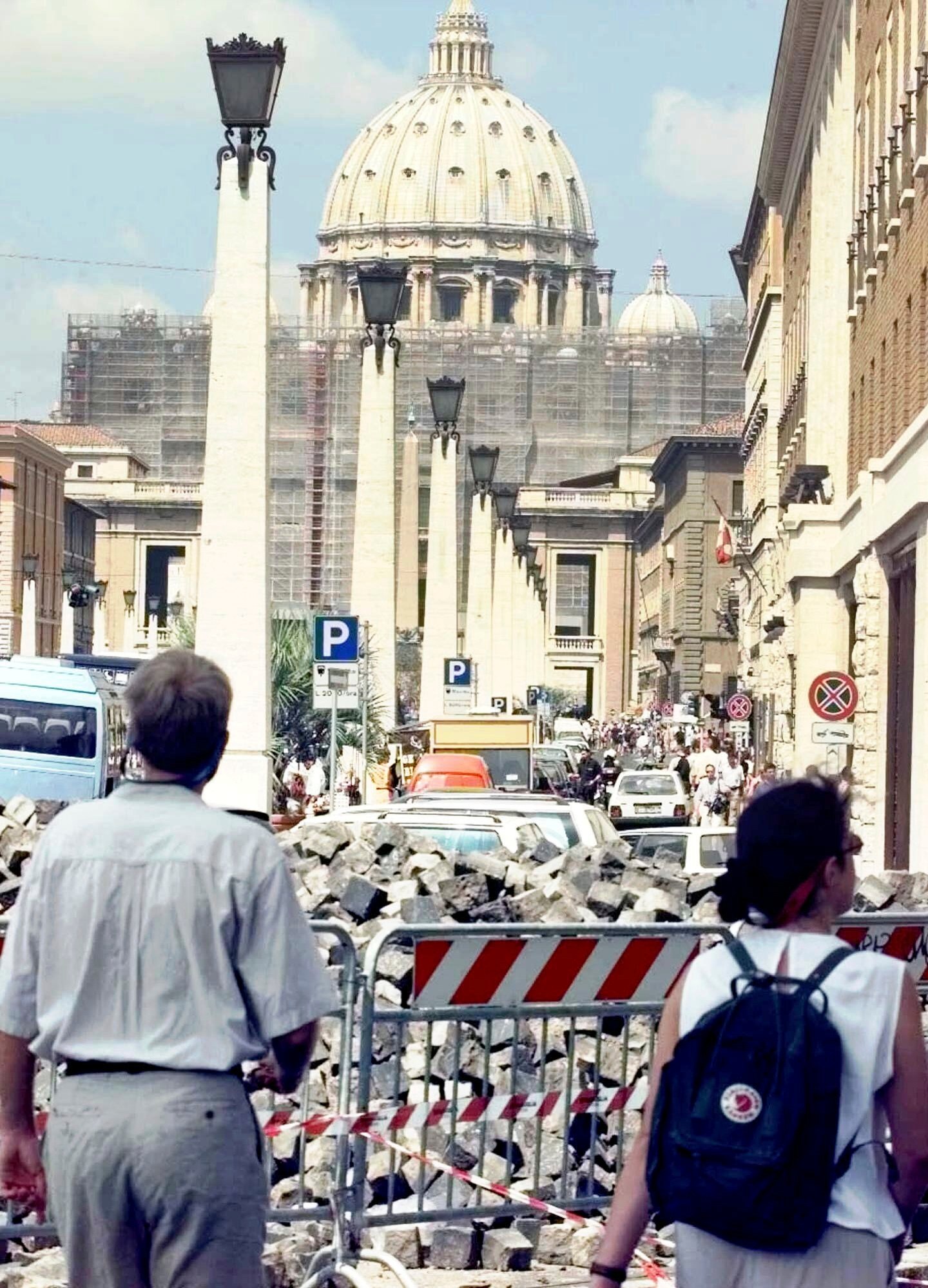 FILE - Tourists approaching the Vatican's St. Peter's Basilica Saturday, July 11, 1998, walk through street works. (AP Photo/Massimo Sambucetti, File)