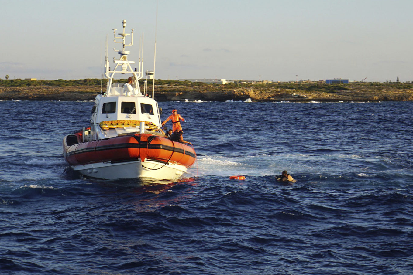 FILE - A man who threw himself in the water from the Open Arms vessel, is intercepted by the Italian Coast guards as he tried to swim to the island of Lampedusa, southern Italy, Tuesday, Aug. 20, 2019. (AP Photo/Francisco Gentico, File)