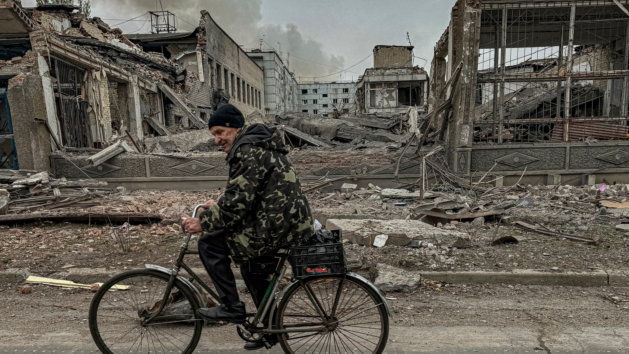 FILE - A man rides on a bike in front of the mail office which was destroyed by a Russian airstrike in Kurakhove, Donetsk region, Ukraine, on Nov. 7, 2024. (AP Photo/Anton Shtuka, File)