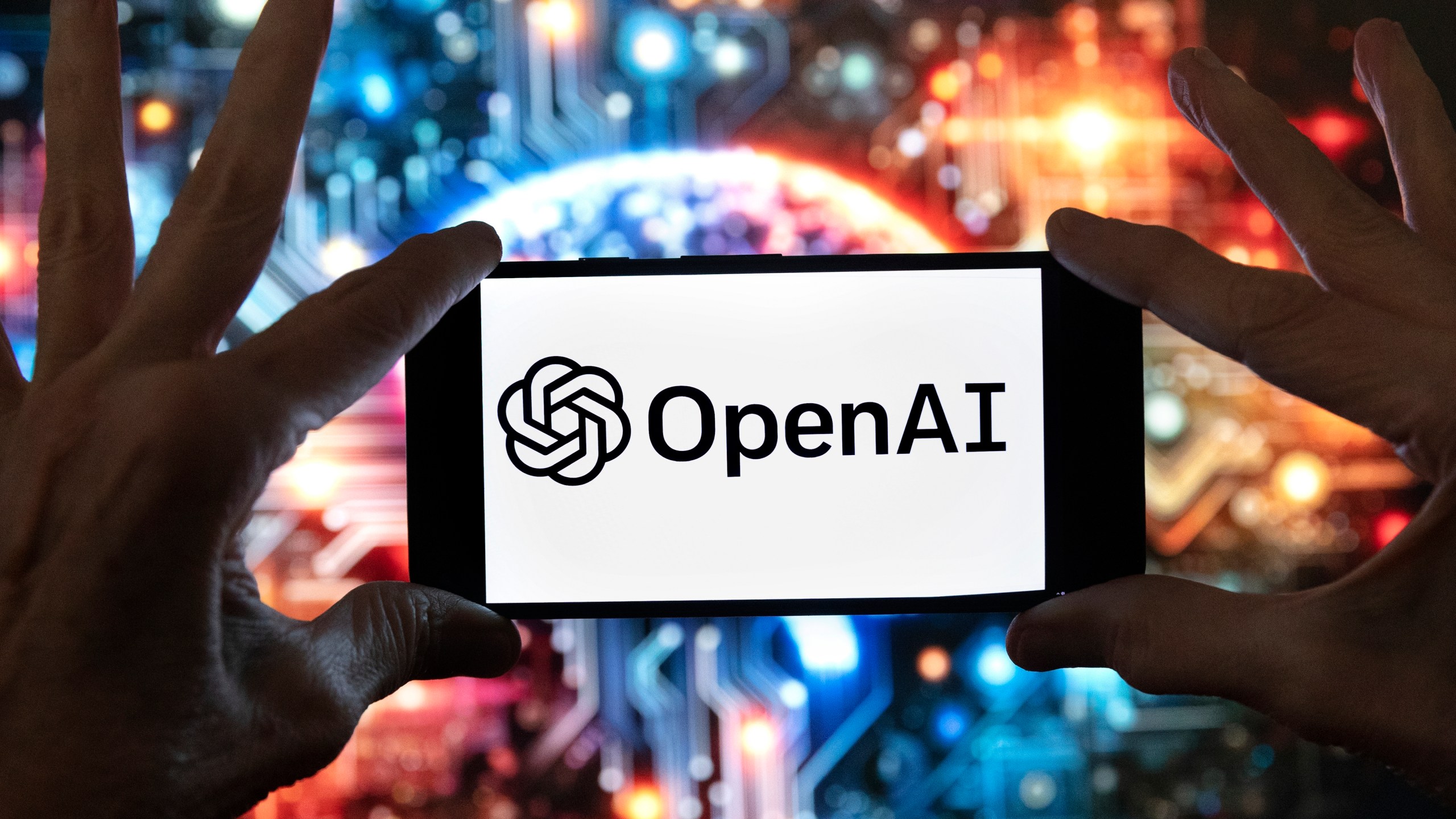 FILE - The OpenAI logo is displayed on a cell phone in front of an image generated by ChatGPT's Dall-E text-to-image model, Dec. 8, 2023, in Boston. (AP Photo/Michael Dwyer, File)