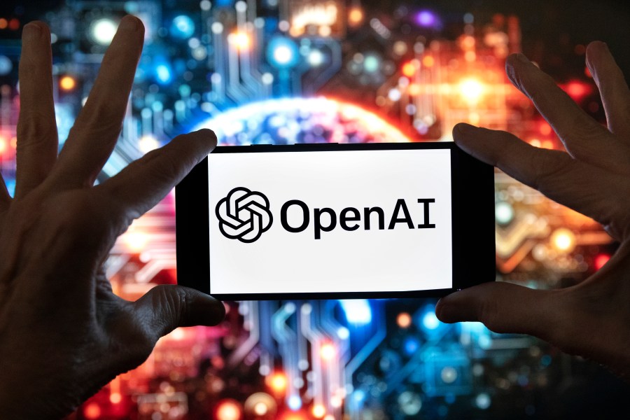 FILE - The OpenAI logo is displayed on a cell phone in front of an image generated by ChatGPT's Dall-E text-to-image model, Dec. 8, 2023, in Boston. (AP Photo/Michael Dwyer, File)