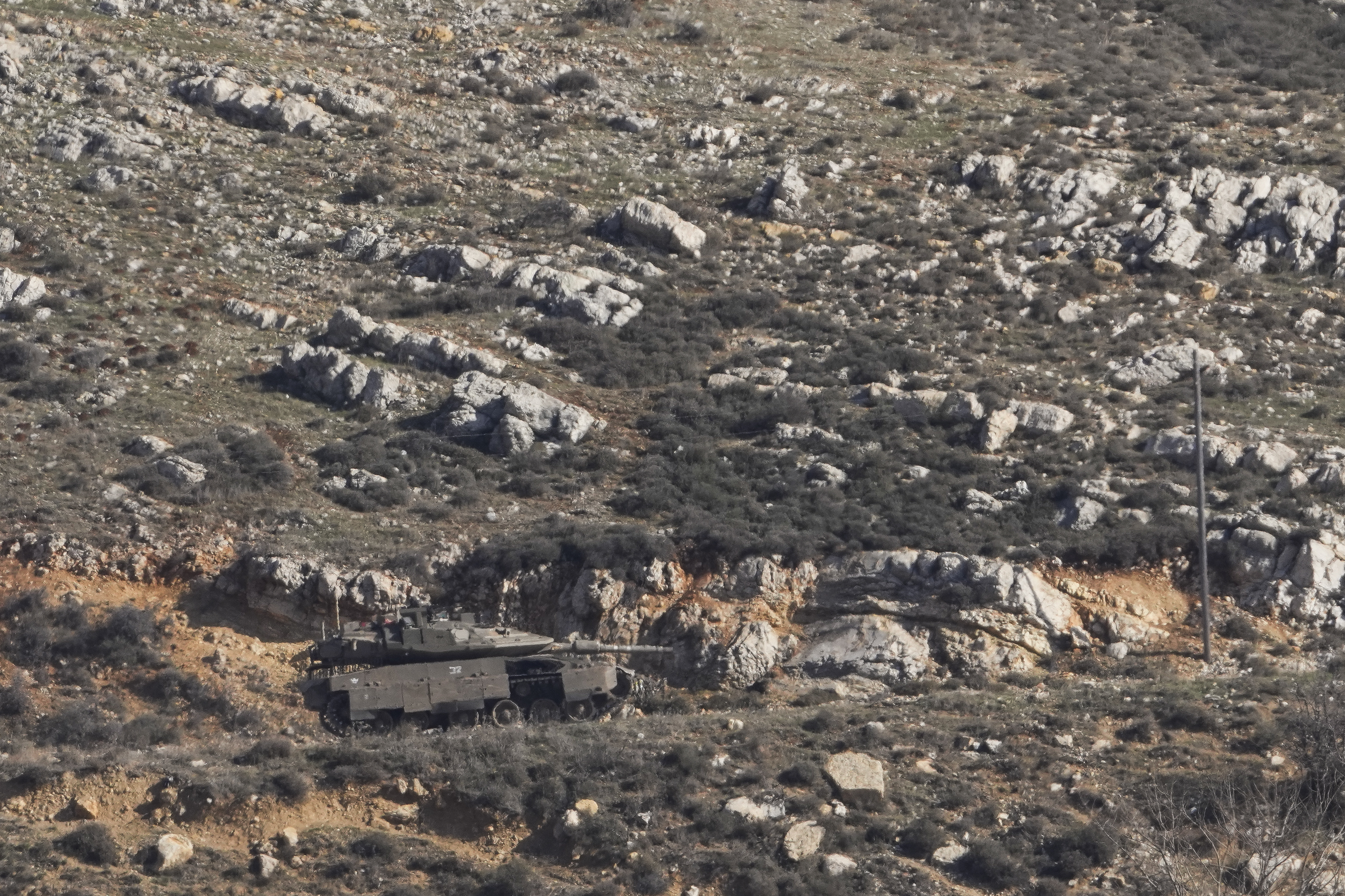 An Israeli tank maneuvers on the buffer zone near the so-called Alpha Line that separates the Israeli-controlled Golan Heights from Syria, viewed from the town of Majdal Shams, Friday, Dec. 20, 2024. (AP Photo/Matias Delacroix)