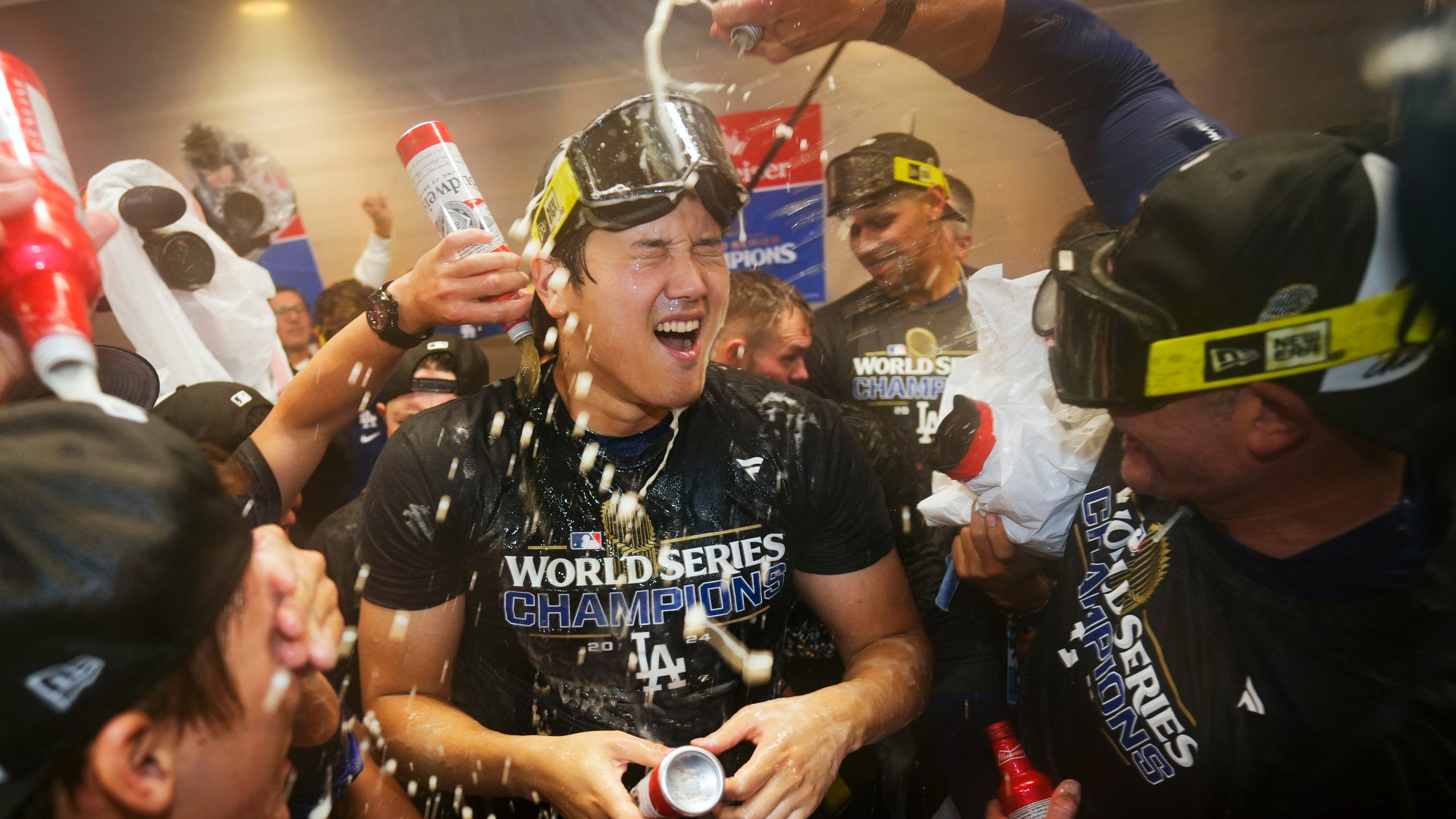 FILE- Los Angeles Dodgers' Shohei Ohtani celebrates in the locker room after their win against the New York Yankees in Game 5 to win the baseball World Series, Thursday, Oct. 31, 2024, in New York. (AP Photo/Ashley Landis, File)