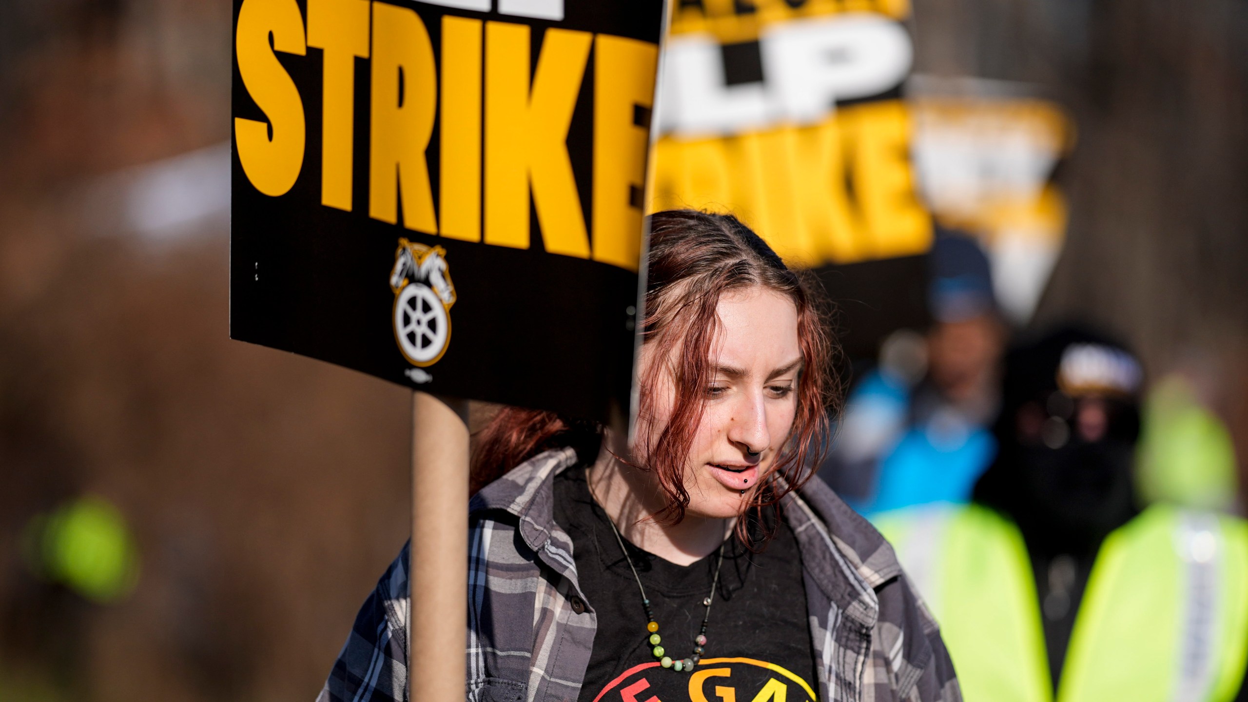 A pro-union demonstrator marches outside an Amazon warehouse, Friday, Dec. 20, 2024, in Alpharetta, Ga. (AP Photo/Mike Stewart)