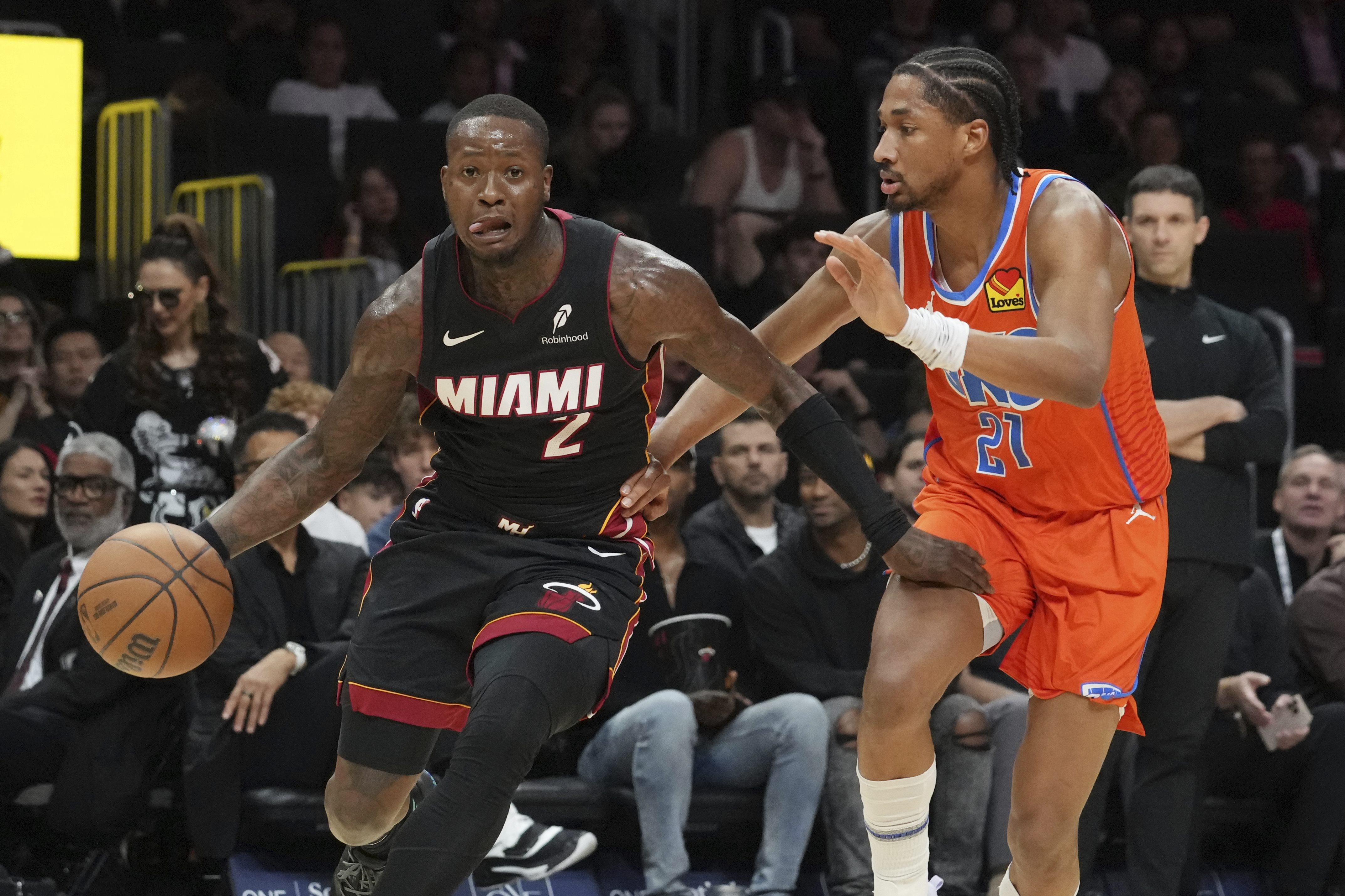 Oklahoma City Thunder guard Aaron Wiggins (21) defends Miami Heat guard Terry Rozier (2) during the first half of an NBA basketball game, Friday, Dec. 20, 2024, in Miami. (AP Photo/Marta Lavandier)