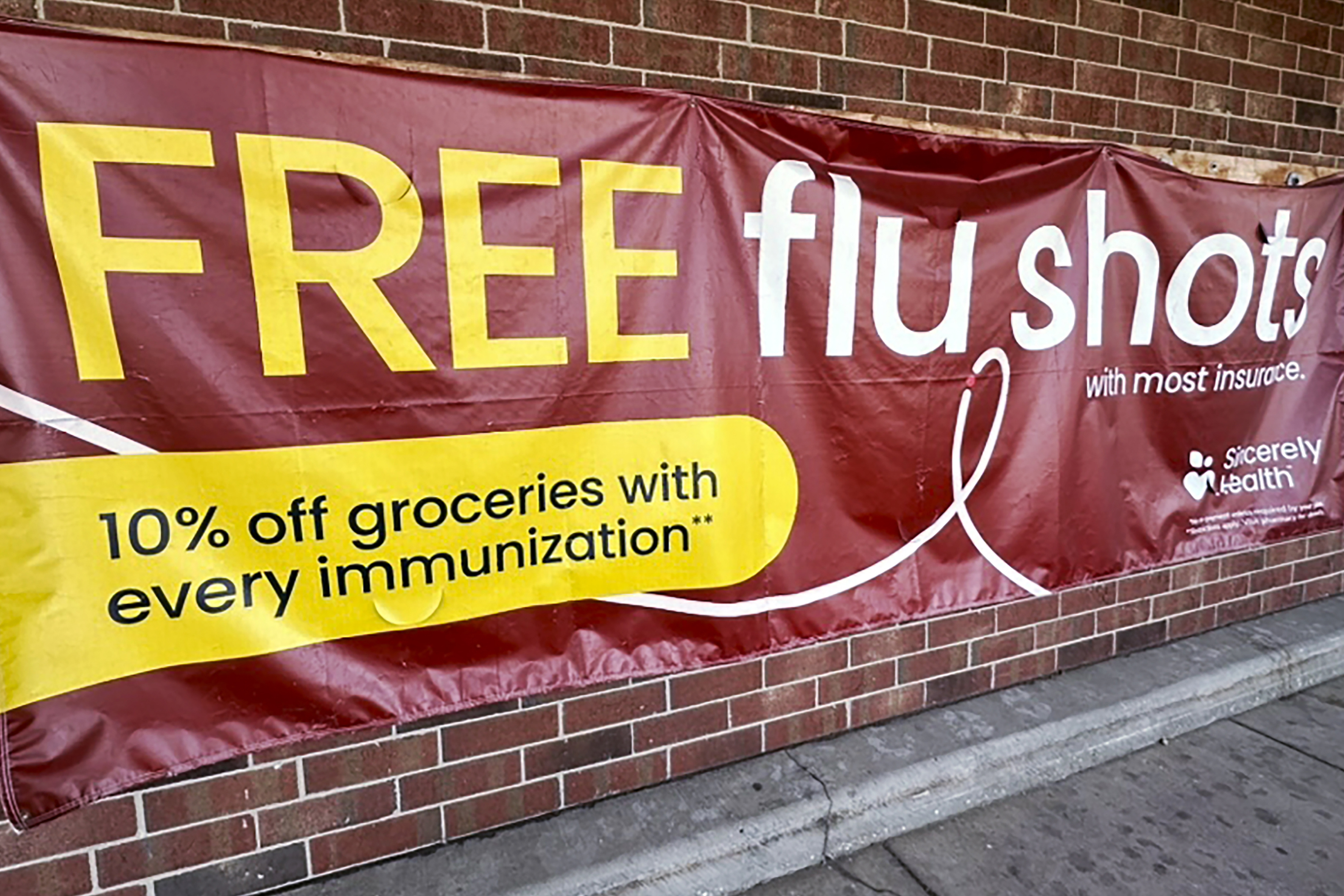 FILE - A sign for flu vaccination is displayed outside of a grocery store in Glenview, Ill., Thursday, Feb. 15, 2024. (AP Photo/Nam Y. Huh, File)