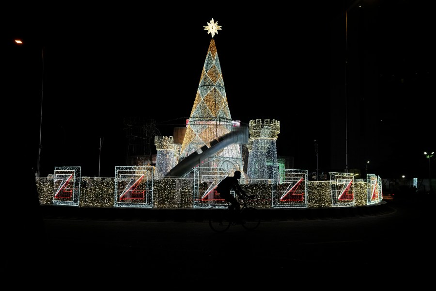 A man rides a bicycle past Christmas decorations on a street in Lagos, Nigeria, Friday, Dec. 20, 2024. (AP Photo/Sunday Alamba)