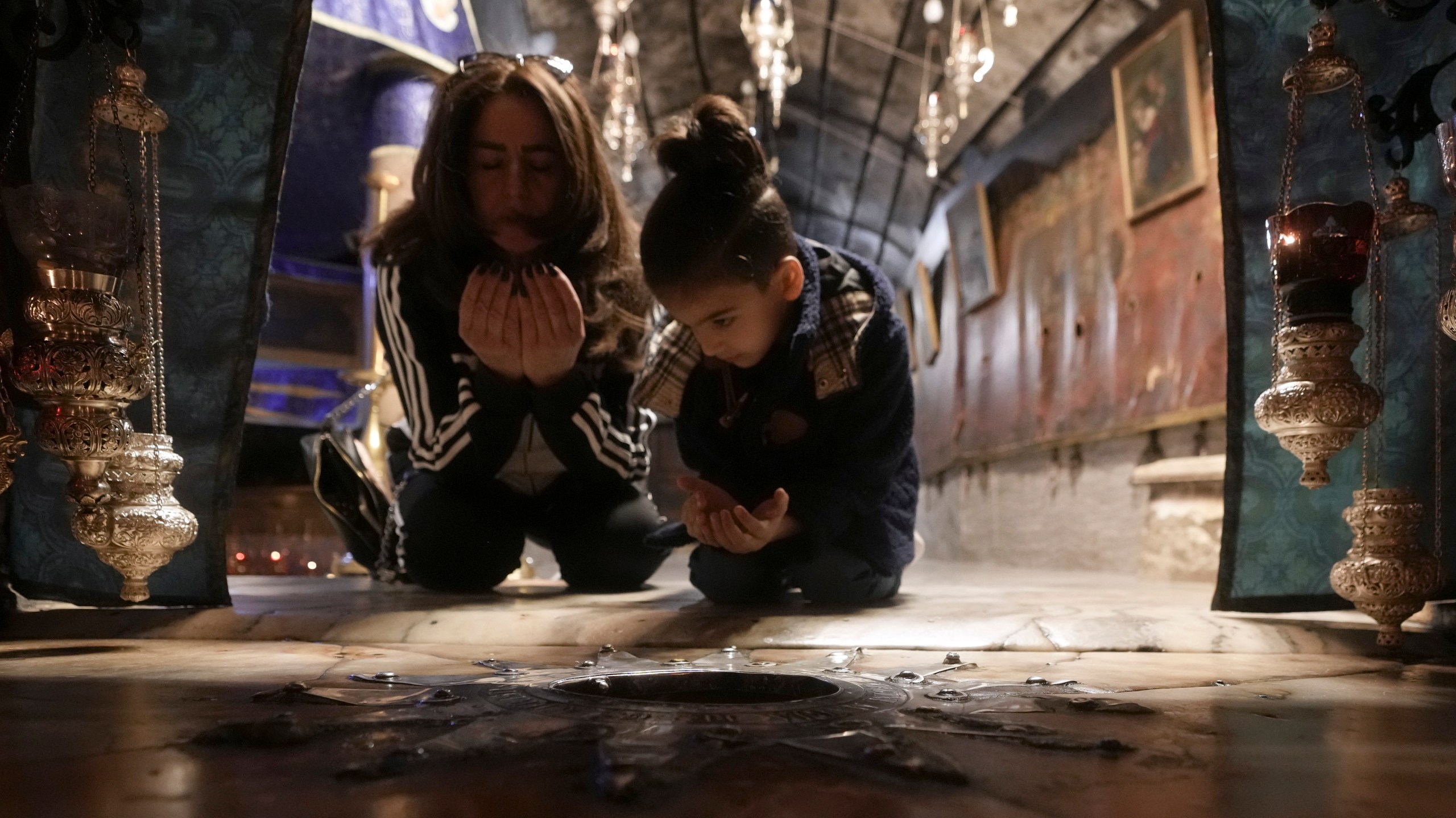 Worshippers pray in the Church of the Nativity, where Christians believe Jesus Christ was born, ahead of Christmas in the West Bank city of Bethlehem, Tuesday, Dec. 17, 2024. (AP Photo/Mahmoud Illean)