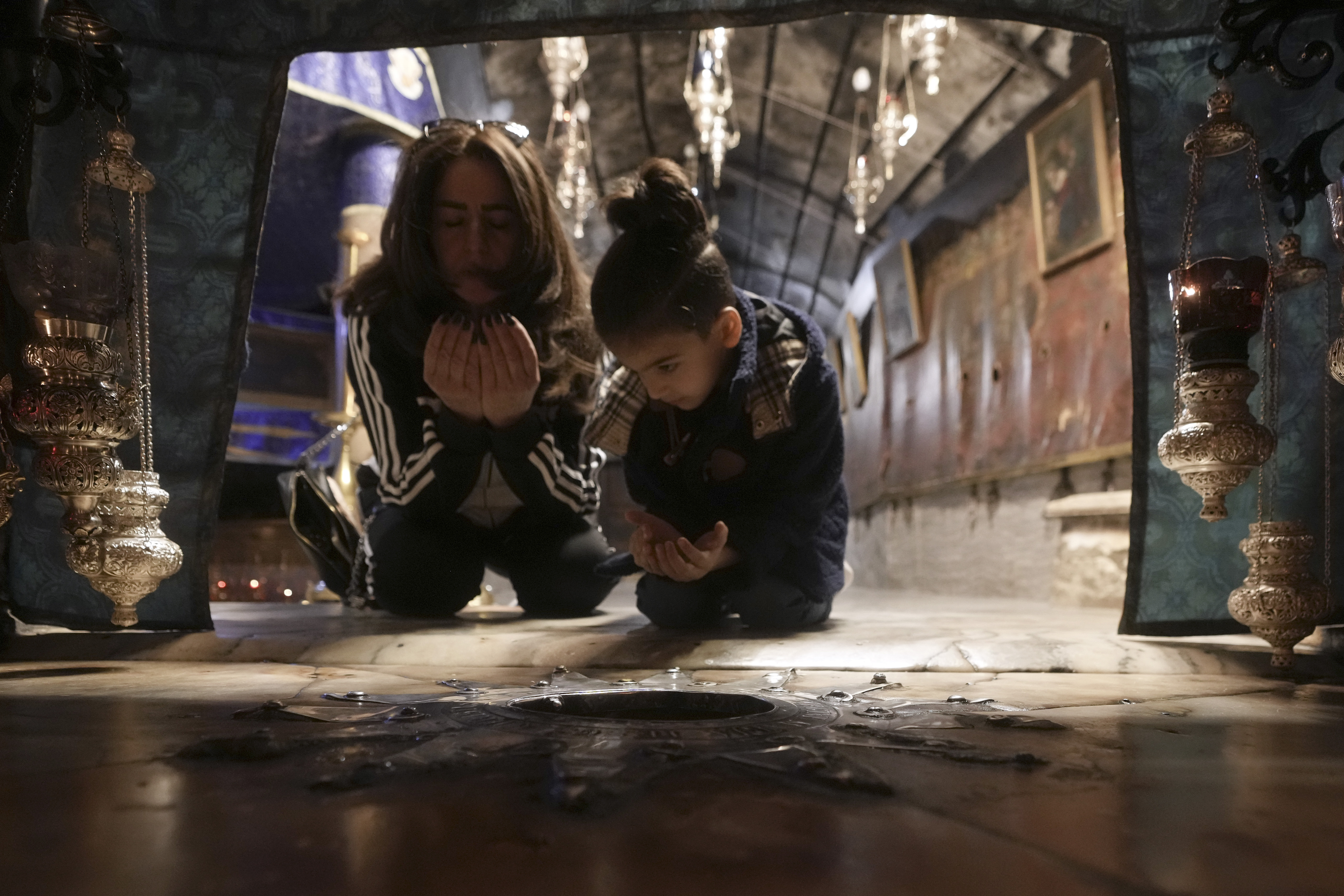 Worshippers pray in the Church of the Nativity, where Christians believe Jesus Christ was born, ahead of Christmas in the West Bank city of Bethlehem, Tuesday, Dec. 17, 2024. (AP Photo/Mahmoud Illean)